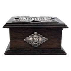 Joyero de madera con decoración plateada y "joyas" en el interior, forro de terciopelo rosa