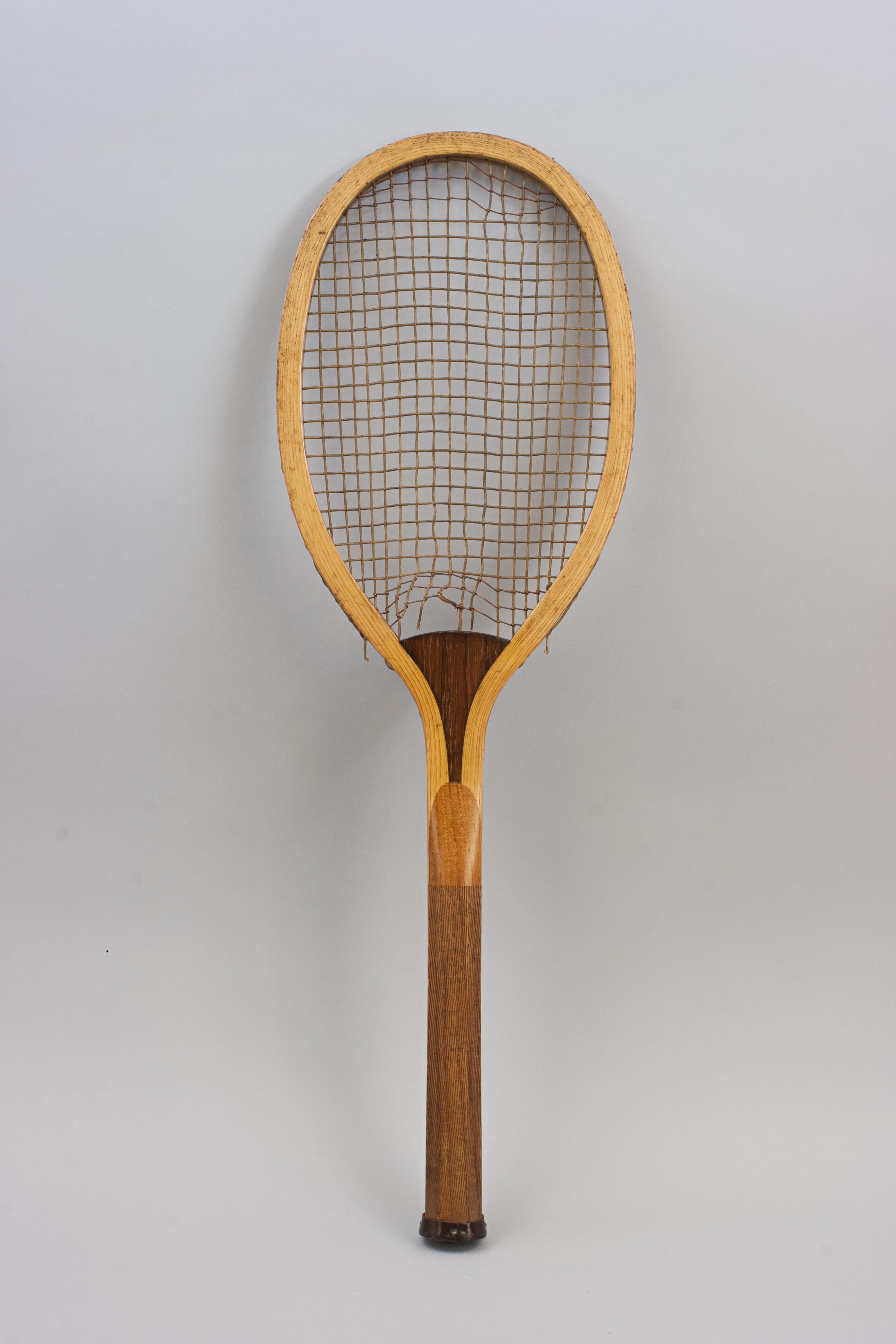 Wooden Lawn Tennis Racket, WONDER
A nice ash frame lawn tennis racket with unusual long and narrow shape head, with convex walnut wedge. The wedge is stamped 'Wonder'. The racket has the original gut strings, three rows of trebling to the top and