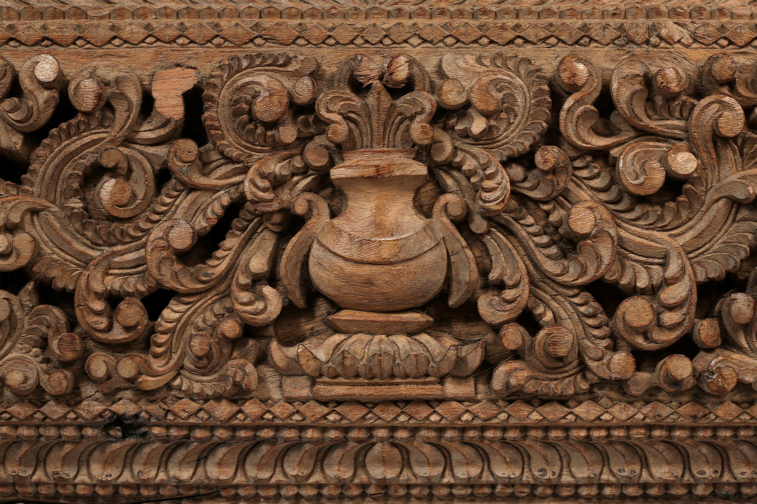 Wooden Lintel Frieze carved in deep relief with two stylized birds, both facing inwards towards an offering box, surrounded by scrolling tendrils, and bordered by geometric carvings. South India, late 19th-20th century.