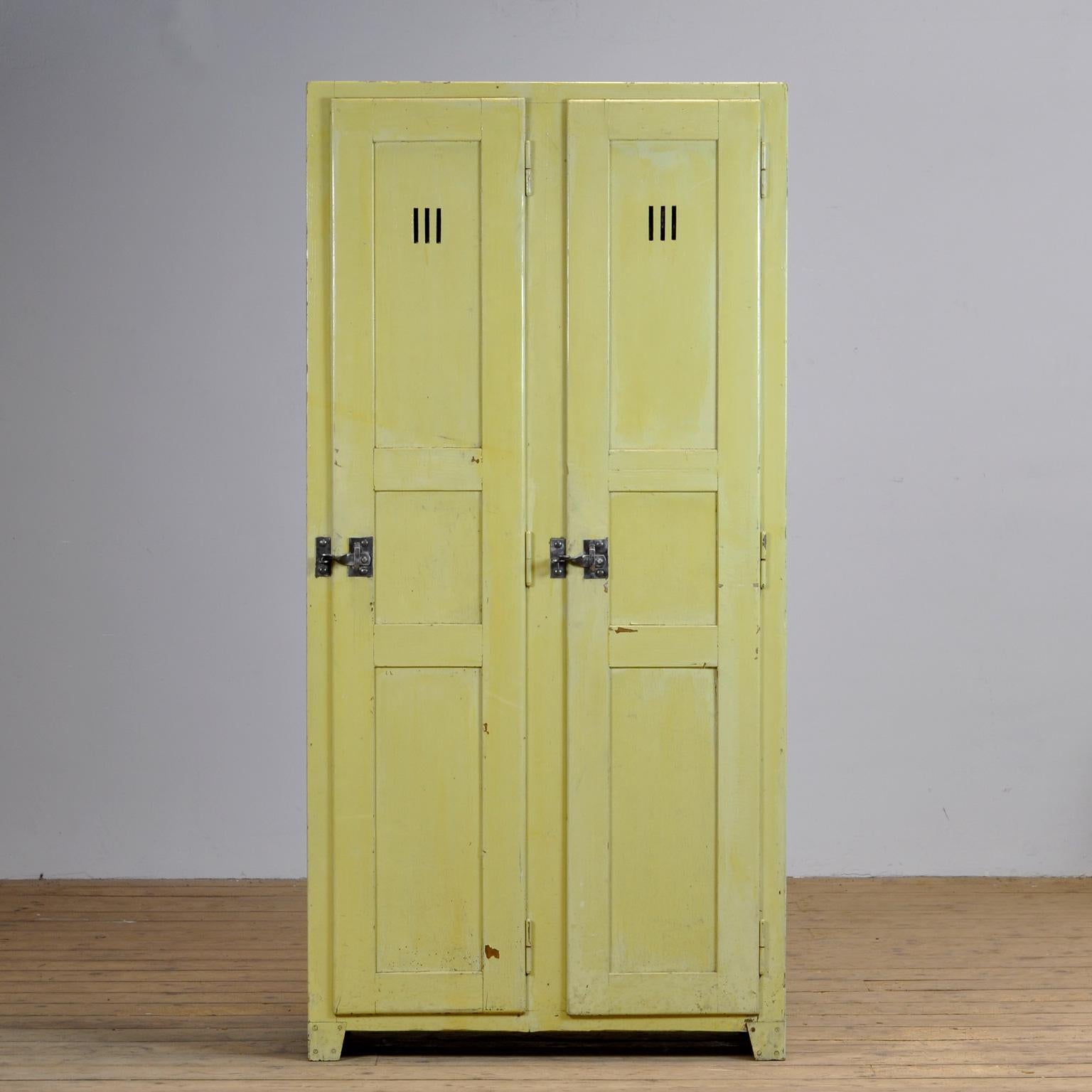 Wooden locker from the 1930s. The cabinet is made of pine and plywood. The locker has storage compartments at the top and about 30 clothes hooks in the lower part and on the inside of the doors. Nice locks on the two doors.