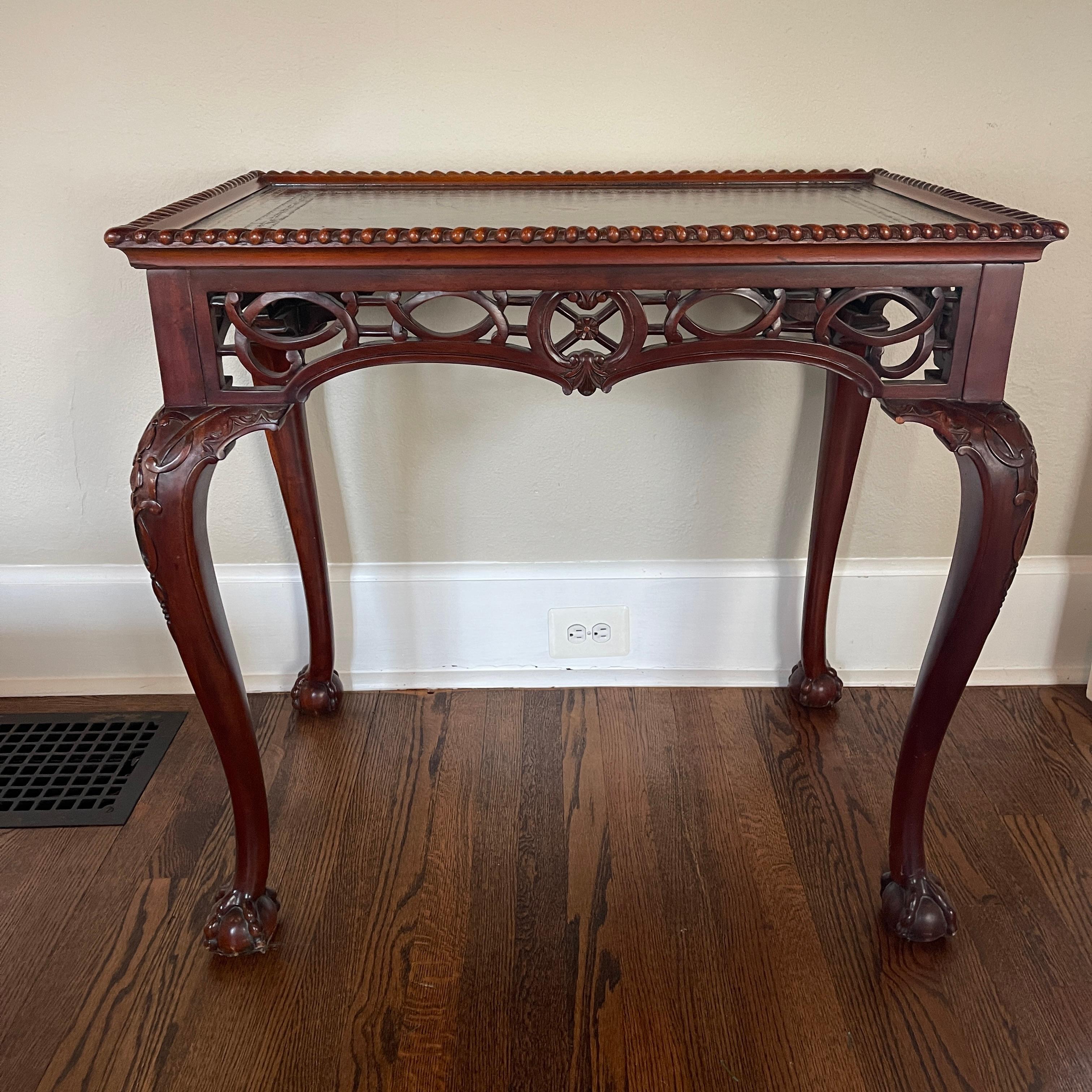 In the style of classic 19th century Thomas Chippendale Fret work carved end table. This lovely table is perfect as an end table or side table by a sofa or chair. The inlay leather top is in good condition with center medallion design. The carved