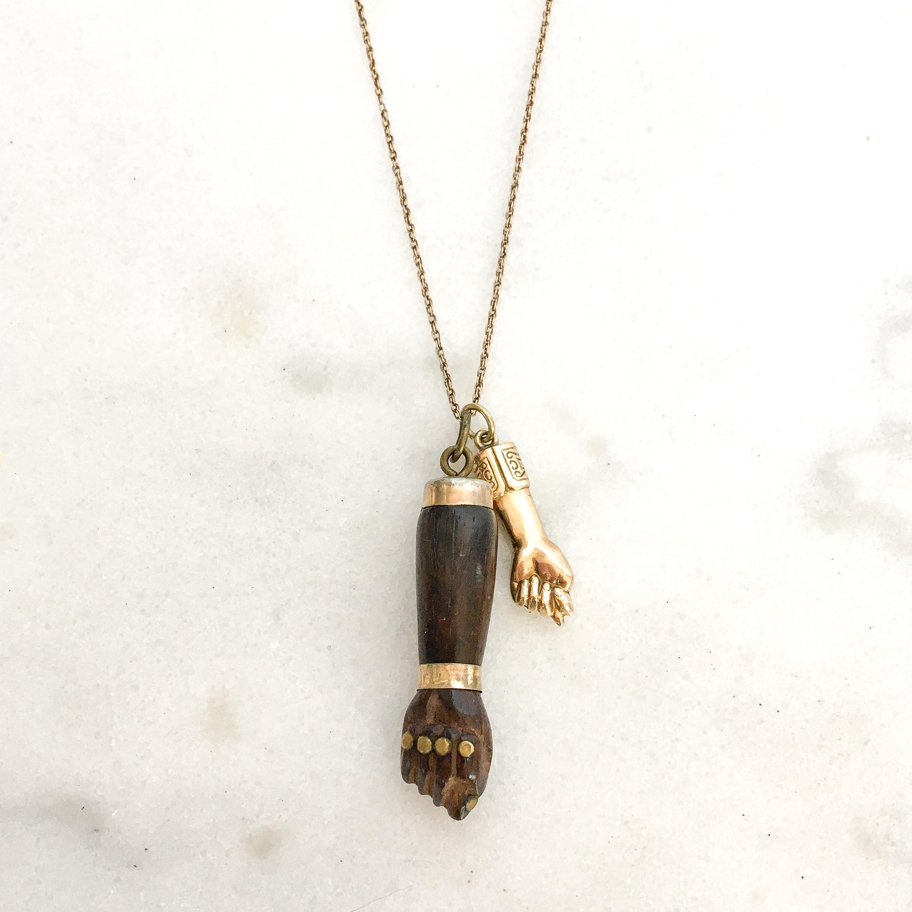 This vintage figa is carved of dark wood with a a gold band on the wrist. The fingernails are beautifully gold lacquered. The top and bail are made from base metal. A great piece to add to your charm bracelet or necklace. The charm comes without the