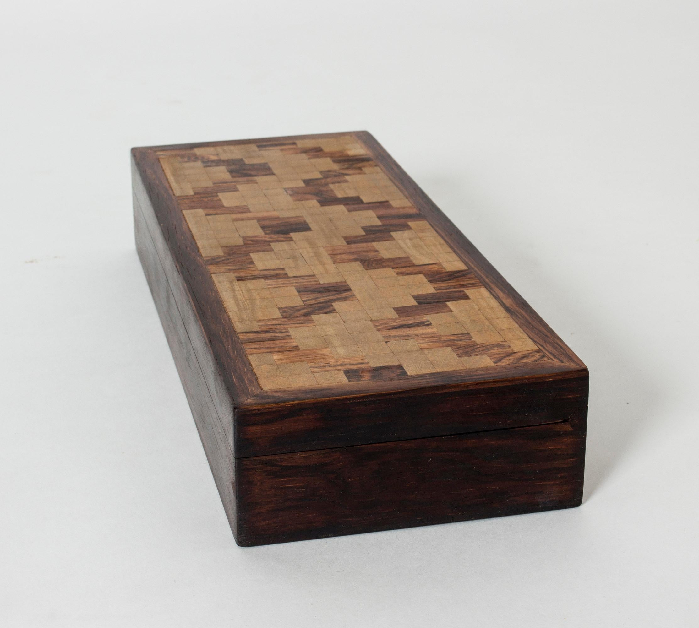 Rosewood case by Alfred Klitgaard, in a sleek design with an amazing graphic pattern of different color wood on the lid.