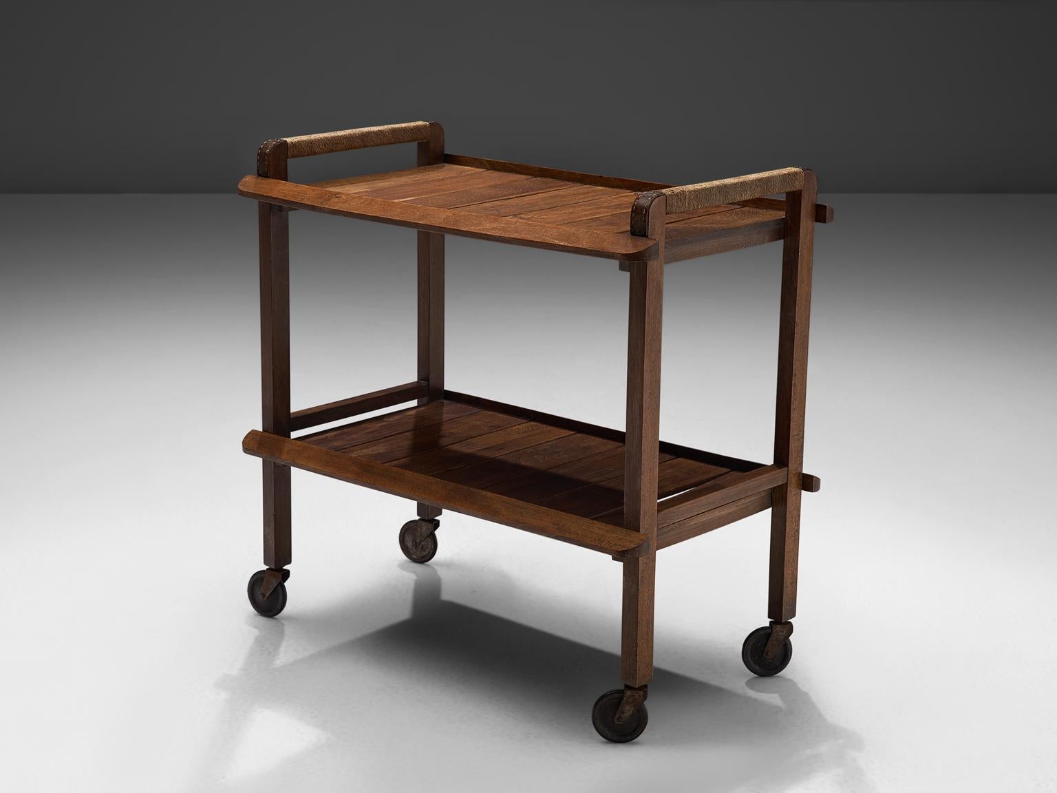 Trolley, wood, cord, metal, France, 1950s.

This solid bar cart has been executed with wooden top and bottom shelves. The piece has a solid wooden frame that has patinated over time and forms a warm, striking contrast to the cord elements. The