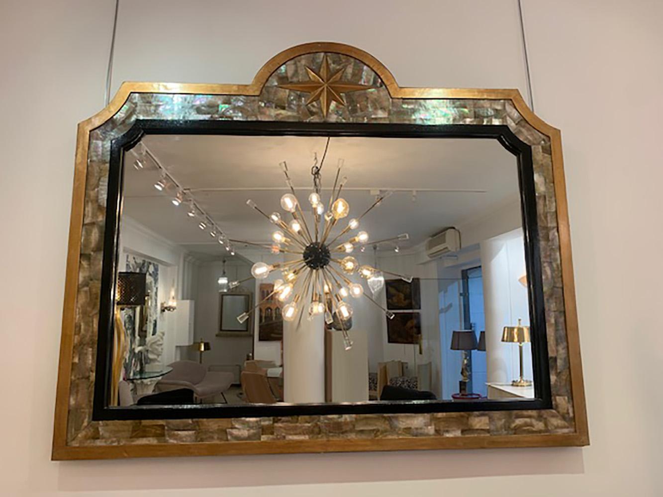 Wooden mirror covered with tahitian mother-of-pearl plates, gilded wrought iron and black lacquer. Circa 1970. 
Measures: H 113
L 137
4800 euros.