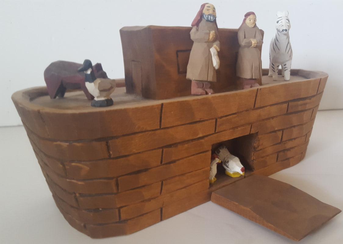 This is a charming, handcrafted, home made version of the biblical Noah's Ark, with hand-carved, wooden human figures of Noah and his wife, along with a handful of representative animals, i.e., a zebra, a duck or goose, a pig, and two chickens. It