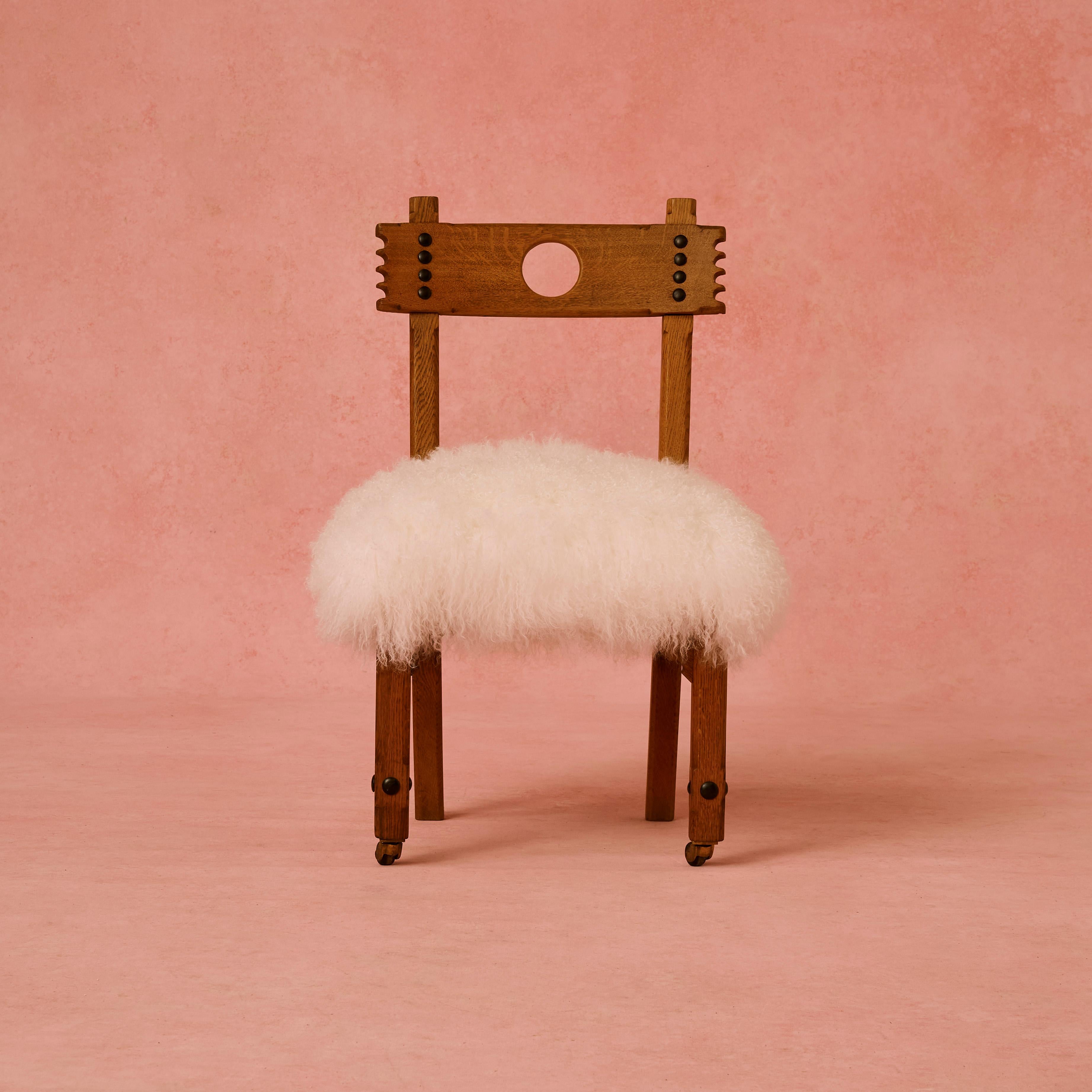 Reformed Gothic chair, attributed to Charles Bevan oak chair upholstered in White Mongolian sheepskin.
 