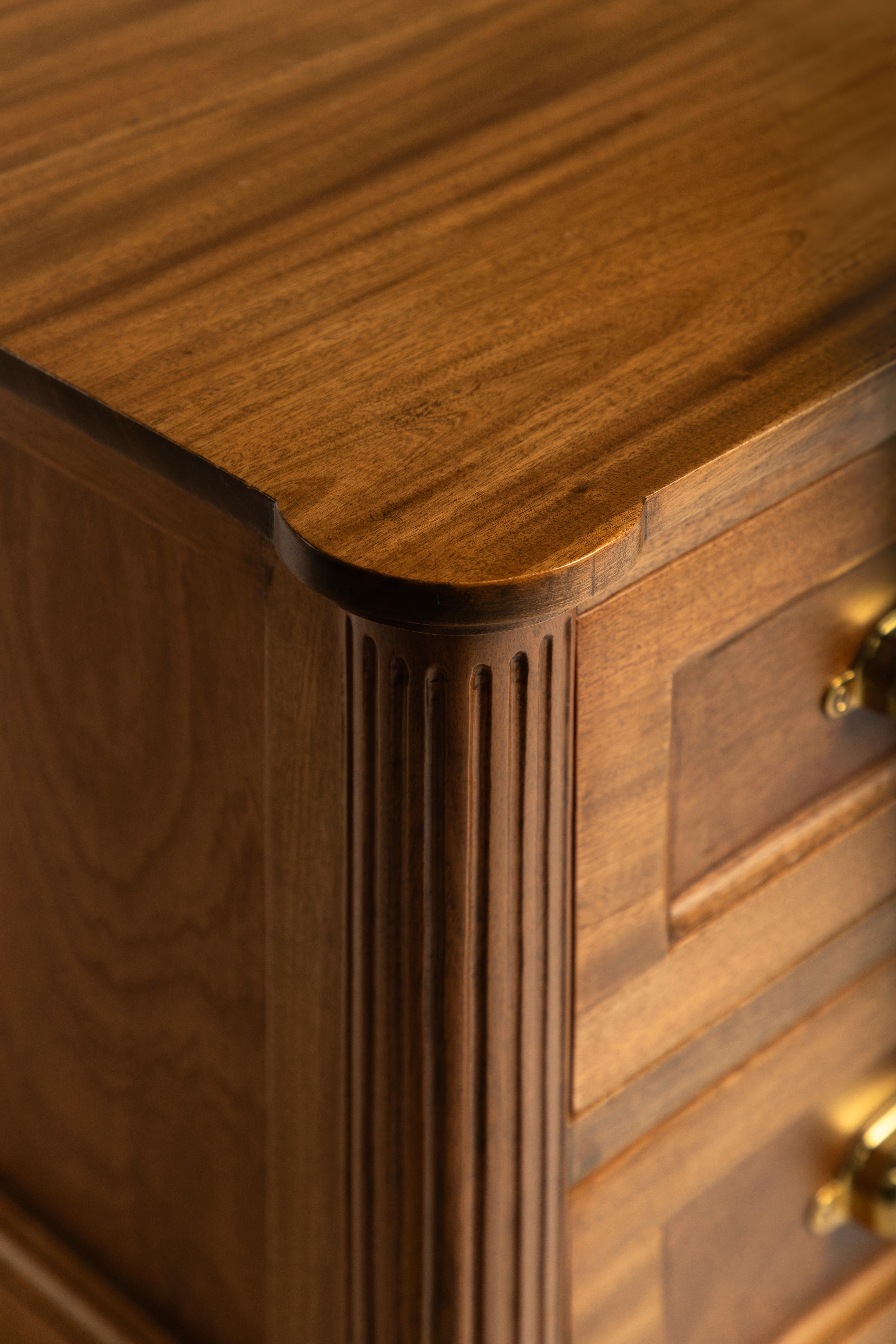 Table de nuit à trois tiroirs en bois de chêne avec détails en laiton et serrure sur l'une des tables de nuit.