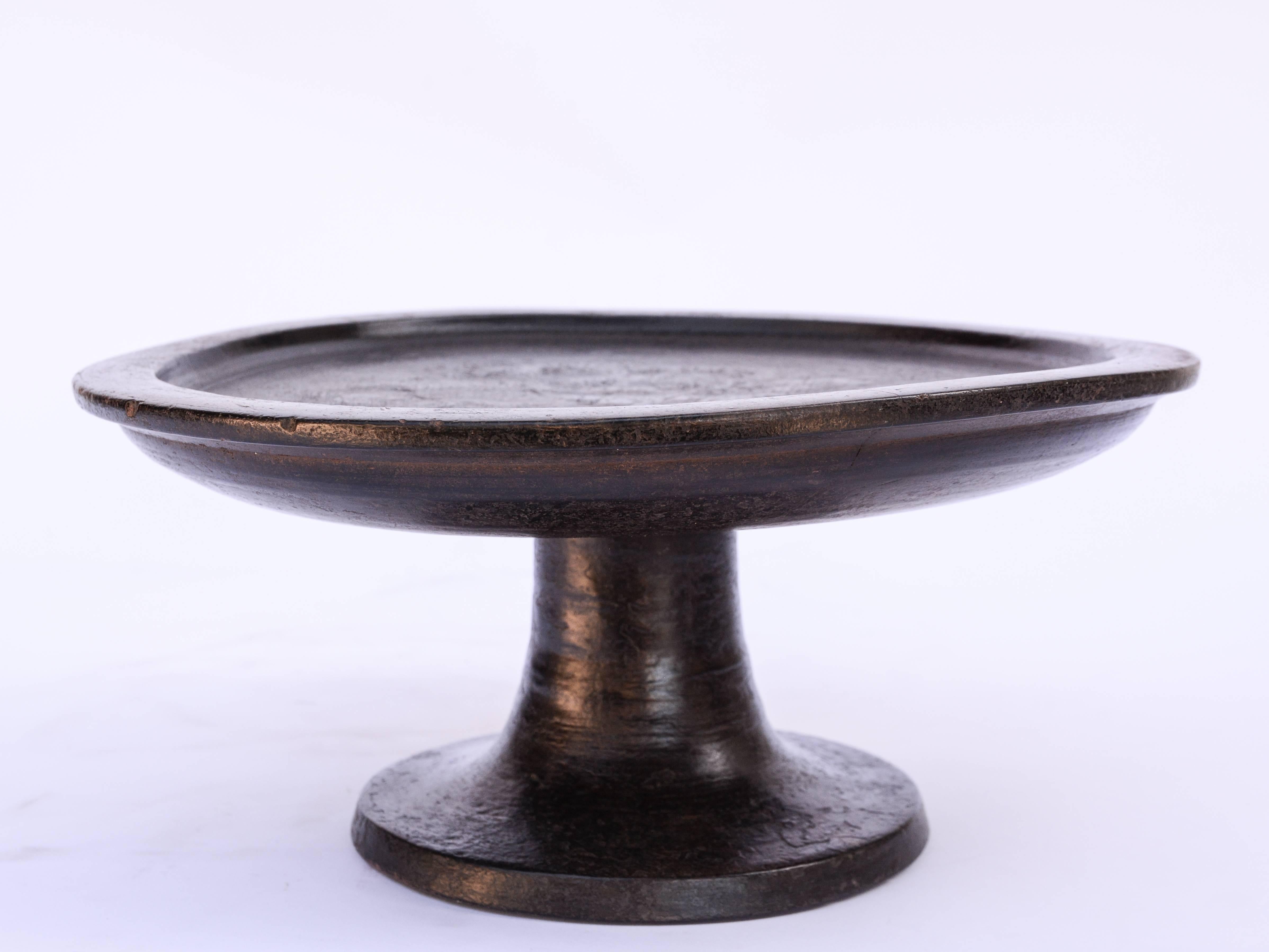 Wooden offering tray on stand, Bali, mid-20th century.
Offered by Bruce Hughes.
This pedestal tray was used in elaborate Balinese rituals to bring offerings of fruit and flowers and present them to the spirits honoured in the ceremony. It is