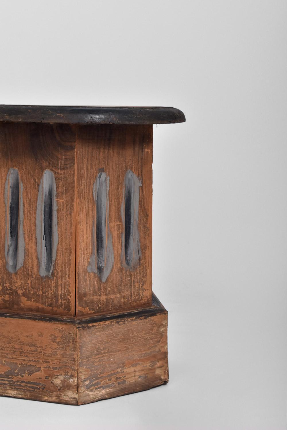 Table d'appoint à colonne octogonale en bois patiné, reposant sur une base octogonale, avec un plateau rond. France, début C.I.C.