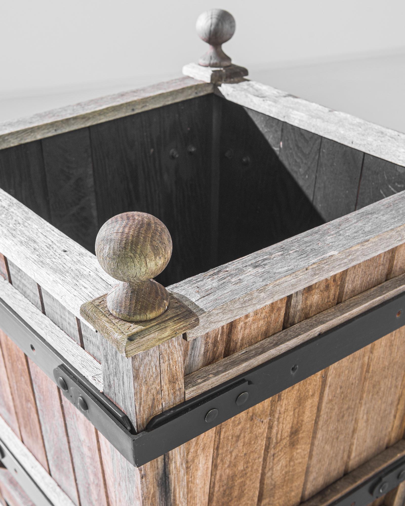An original prototype produced in our atelier. A square barrel elevated off the ground by four short feet, this ironbound box is crowned by a quartet of pommels. Weather worn, with a dark interior to detract from dirt, this plucky planter is primed