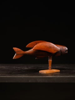 Wooden sculpture Pitcairn Flying Fish on museum stand.