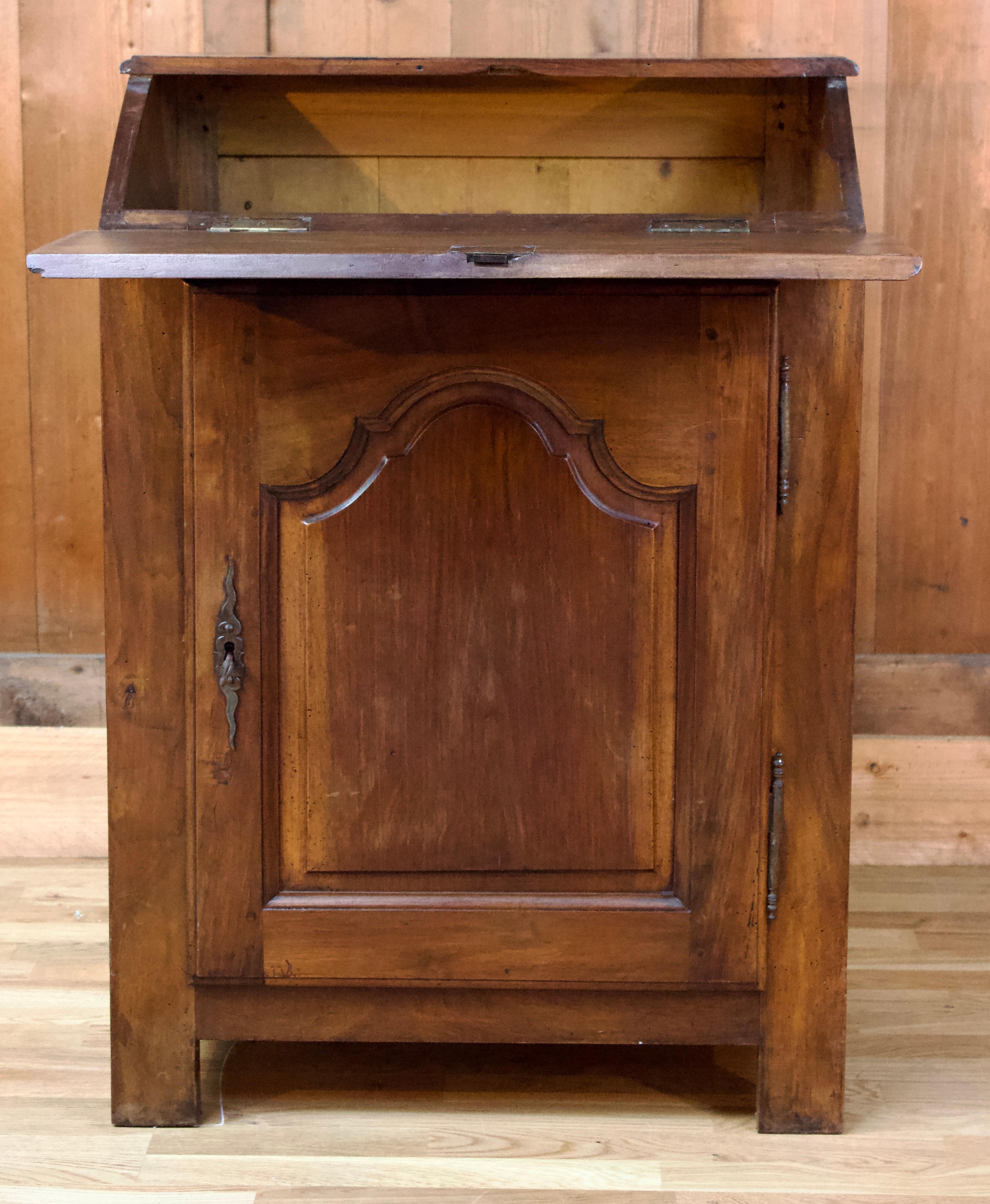 This desk is composed of a cupboard and an openable drawer. Very nice piece of ironwork in metal trim. This little « Bureau de pente »  is in solid wood. 
France 19th century.