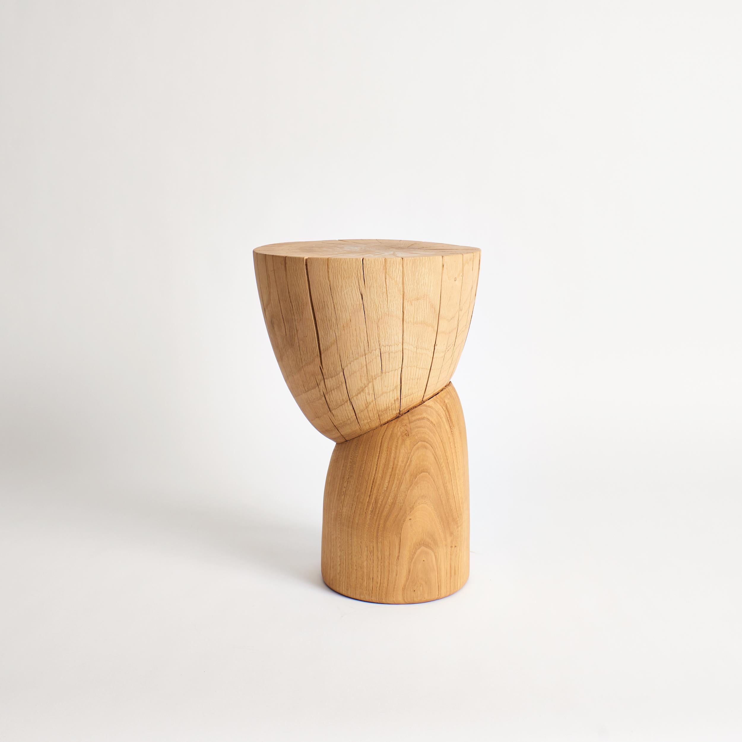 Wooden side table in natural by Project 213A
Dimensions: D 30 x W 30 x H 43.5 cm
Materials: Chestnut wood. 

This sculptural side table is hand carved by local artisans in Portugal using solid wood. Available in natural or darker brown