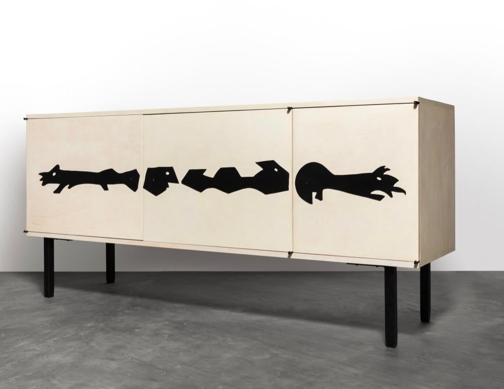 A master with natural materials, this impeccable sideboard was created by Jean Touret for his Atelier de Marolles in 1958. The piece is made from wood and iron; the panels that make up the body of the buffet-style sideboard are made from waxed wood.