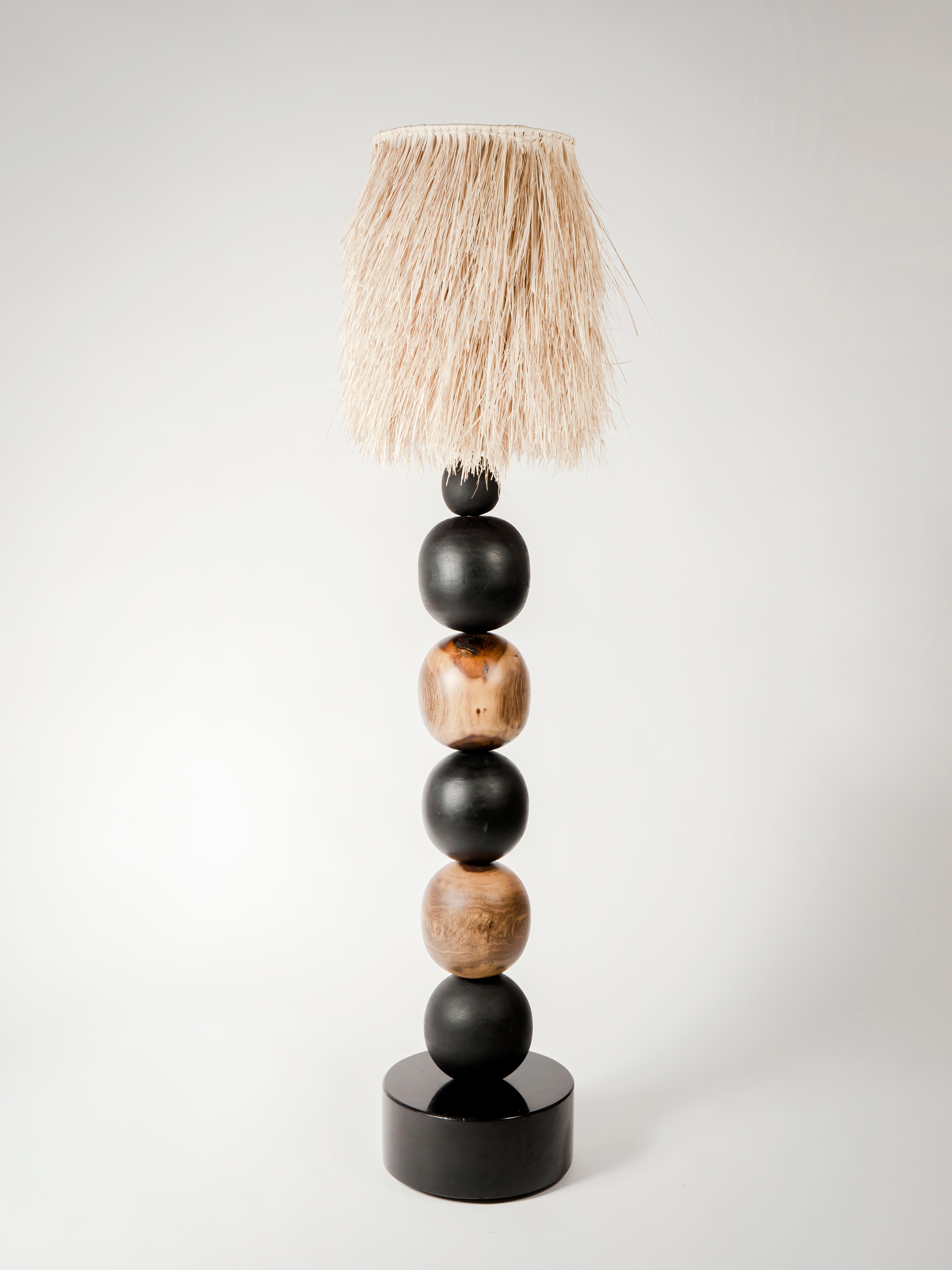 Wooden Spheres Floor Lamp with Palm Screen by Daniel Orozco.
Dimensions: D 35 x H 184 cm.
Materials: Jabin wood, burned wood, stone base, palm screen.

All our lamps can be wired according to each country. If sold to the USA it will be wired for