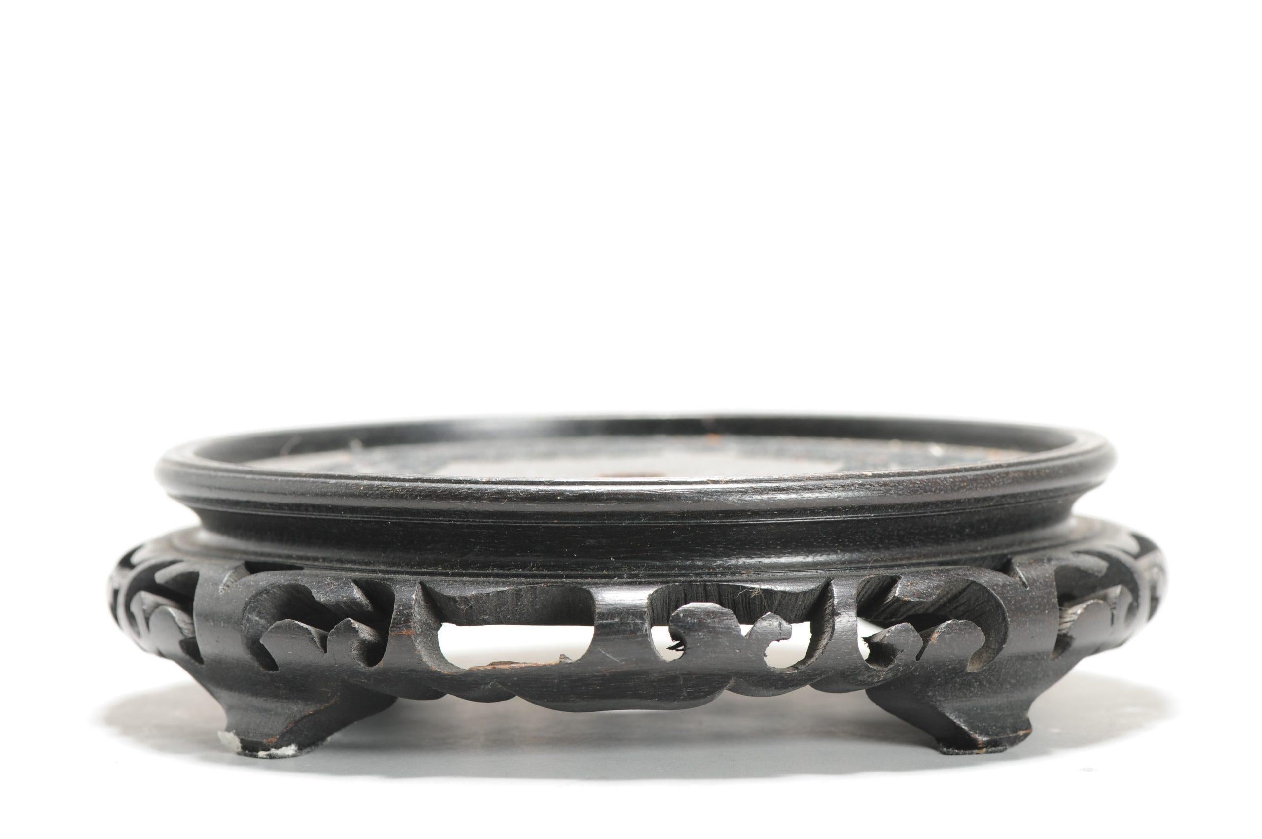 Aquí tenemos un bonito soporte de madera para platos

Más información:
Material: Porcelana y cerámica
Región de origen: China, Made Hong Kong
Periodo: mediados del siglo XX
Estado: Algo descolorido
Dimensiones: Tamaño de la superficie útil: 13,4 cm