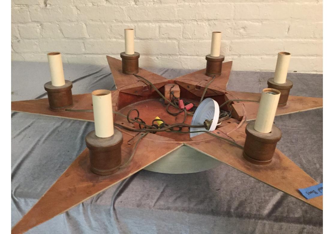A custom Folk Art Style Star Fixture in a subtle cream paint finish. 6 Lights, one in each star point, with copper finish.
Each point is gilt trimmed and there are some areas of roughness/loss on 2.
Dimensions: 45” diameter and 24”