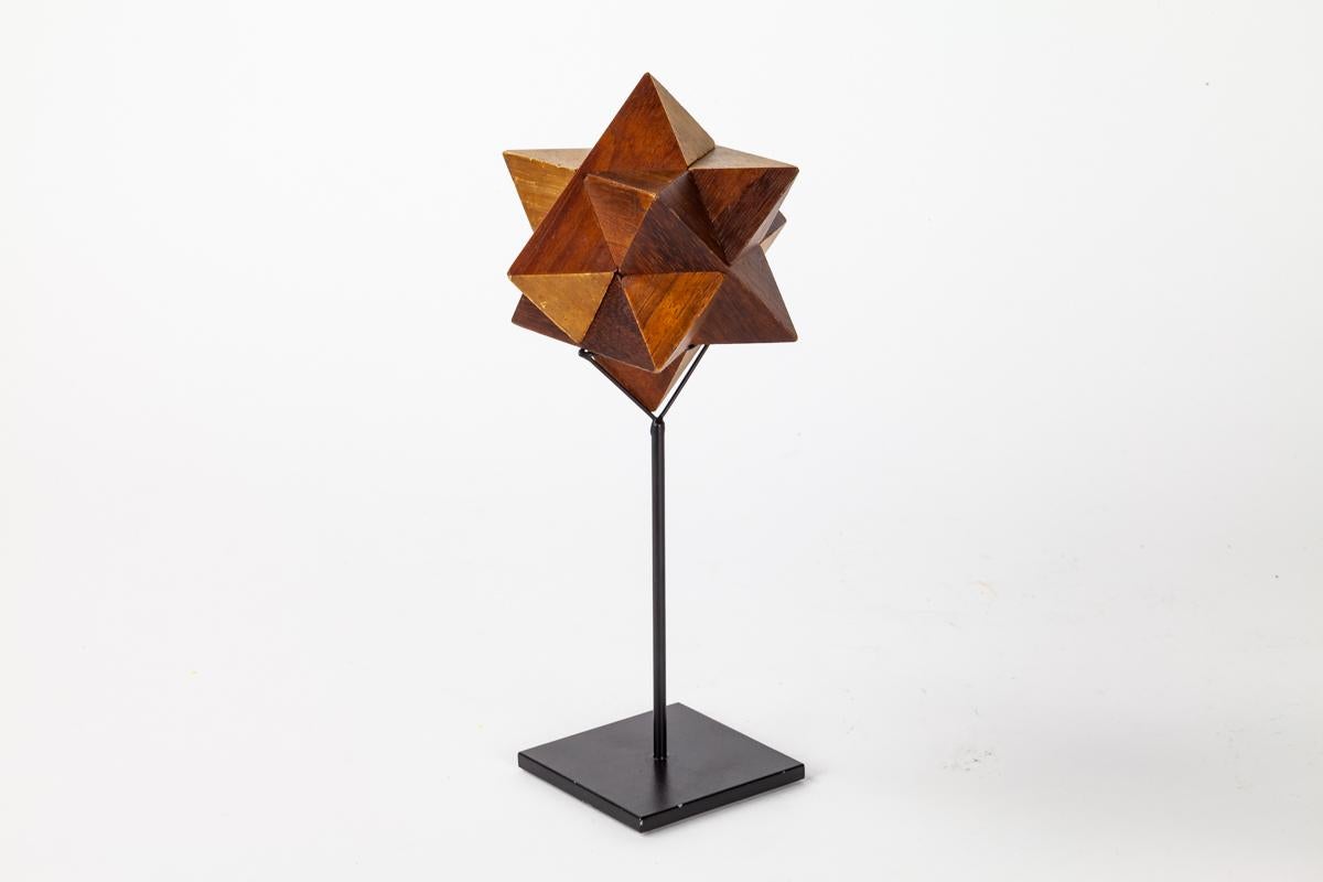 A sculptural wooden star form puzzle that is set an on a custom made stand. The puzzle can be taken off the stand to be appreciated and interacted with.