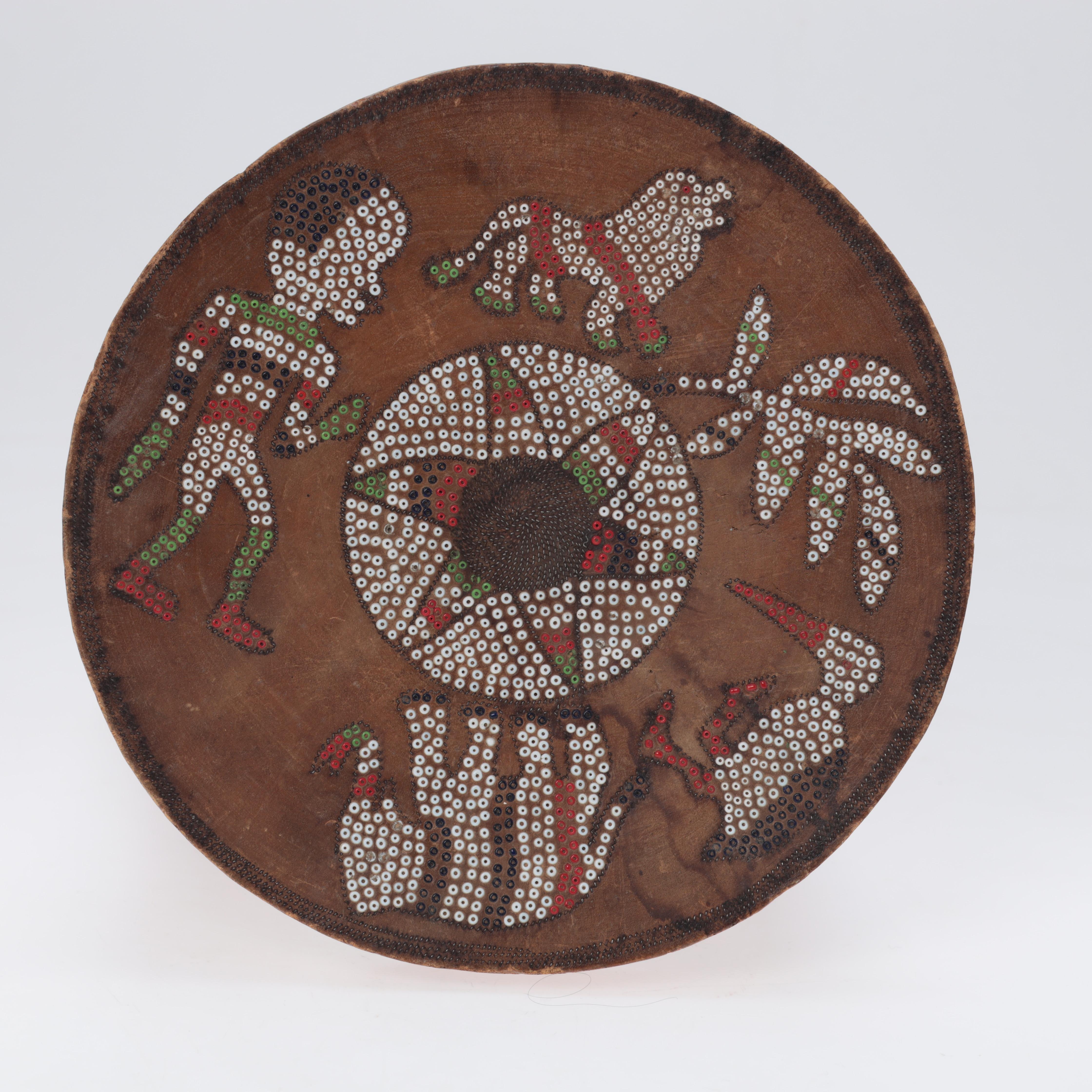 Tabouret/table en bois avec perles incrustées, Kamba, probablement Kenya.
Tabouret sculpté dans une seule pièce de bois avec des perles incrustées sur le dessus représentant une personne et des animaux.
Hauteur : environ 27,5
Diamètre : environ 24,5