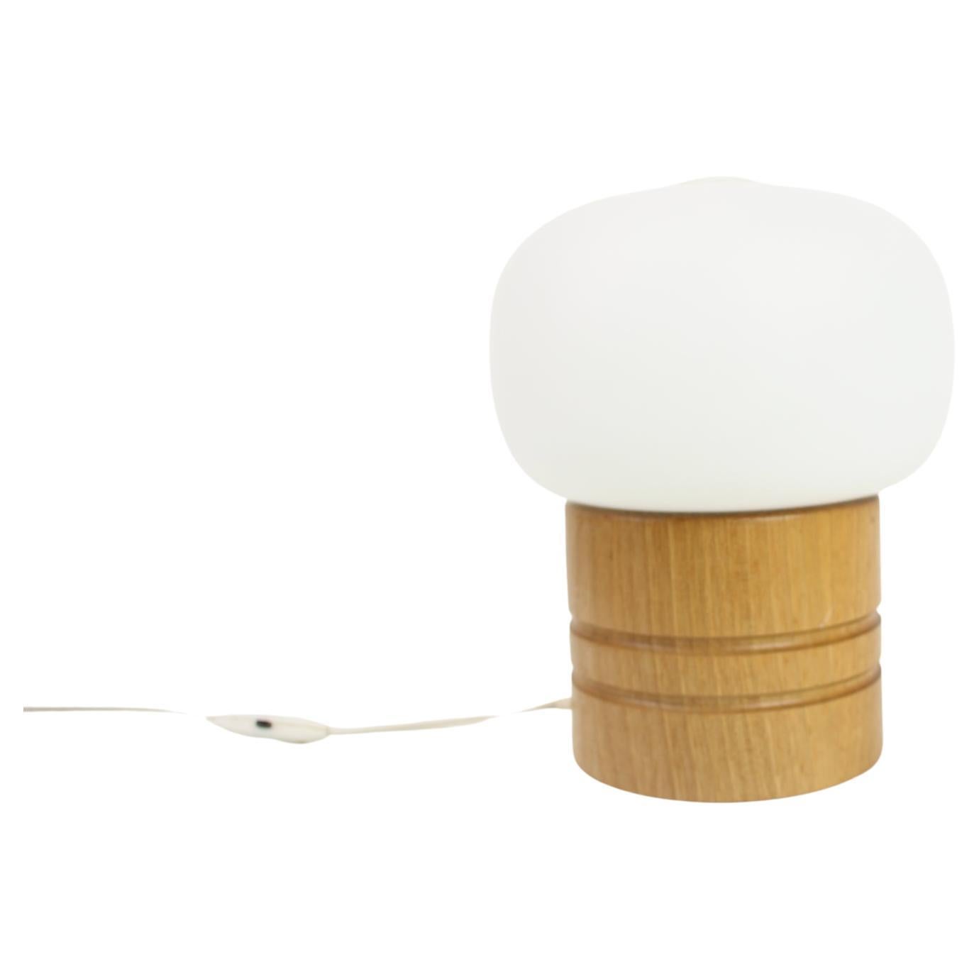 Mid-century table lamp made of milk glass and wood.
Designed by Ivan Jake for Osvetlovaci Sklo in Valasske Mezirici in former Czechoslovakia in the 1970's.
Original wiring, fully functional, cleaned.