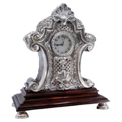 Wooden table regulator clock w/ silver applications 
4 circular support bases