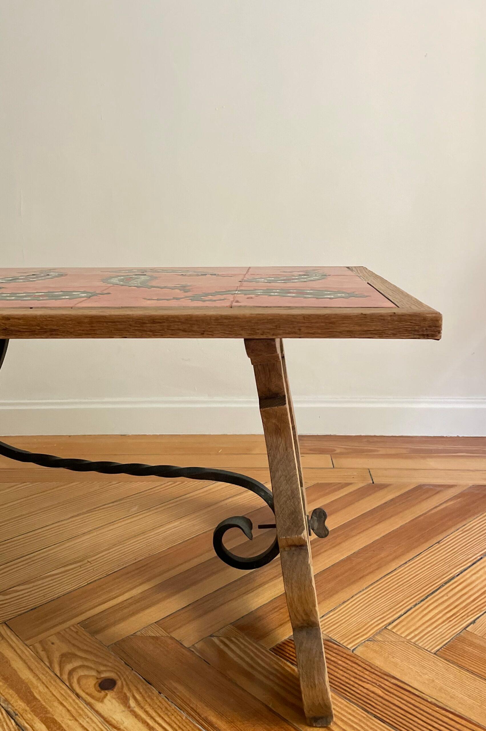 Table en bois avec plateau en céramique émaillée polychromée à la main avec motif géométrique organique.

