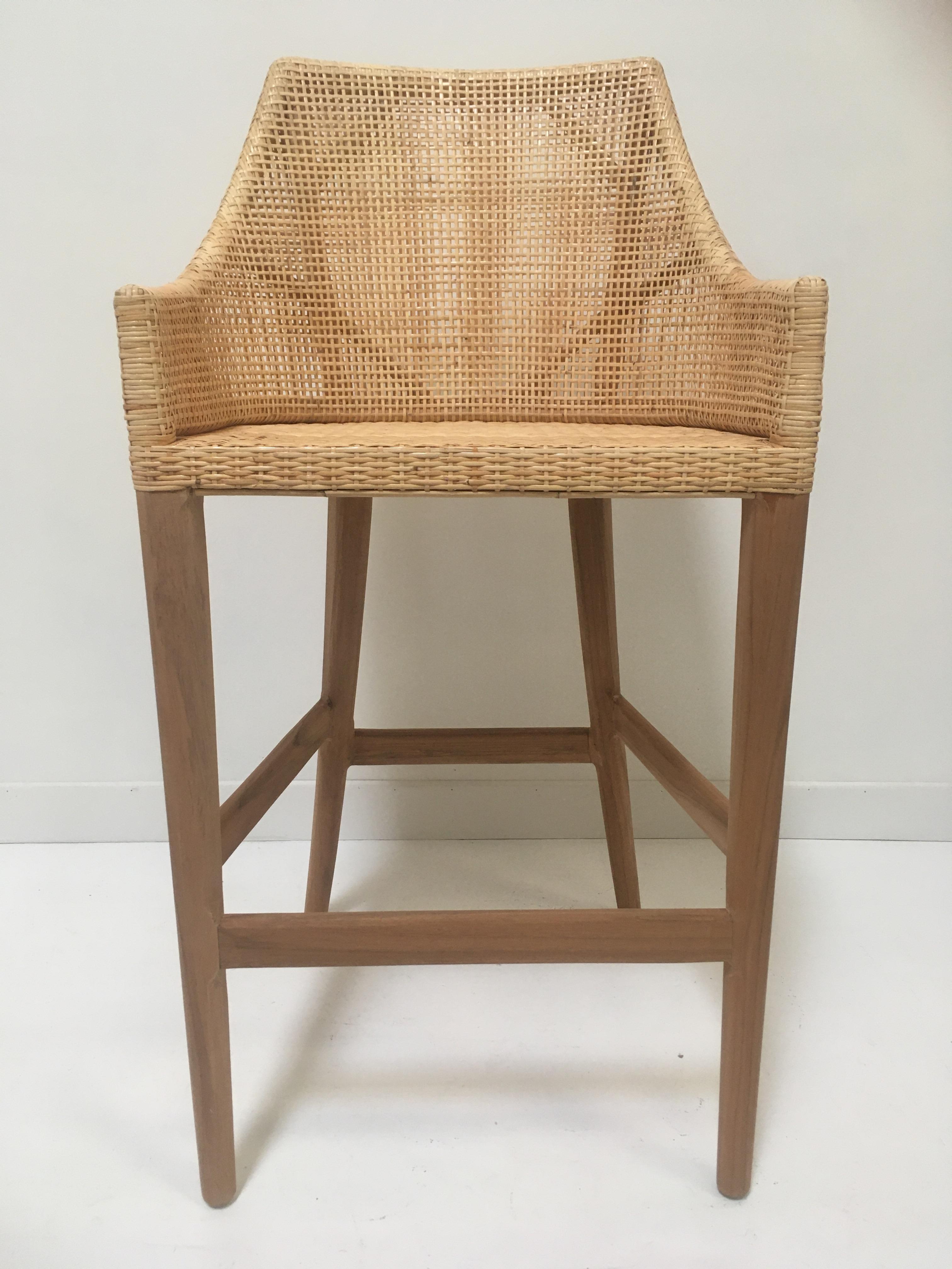 Elegant rattan bar stool with a structure in teak wooden and handbraided rattan wicker cane combining quality, robustness and class. Comfortable and ergonomic, aerial and poetic. The armrests height is 82cm and the seat height is 71cm. In excellent