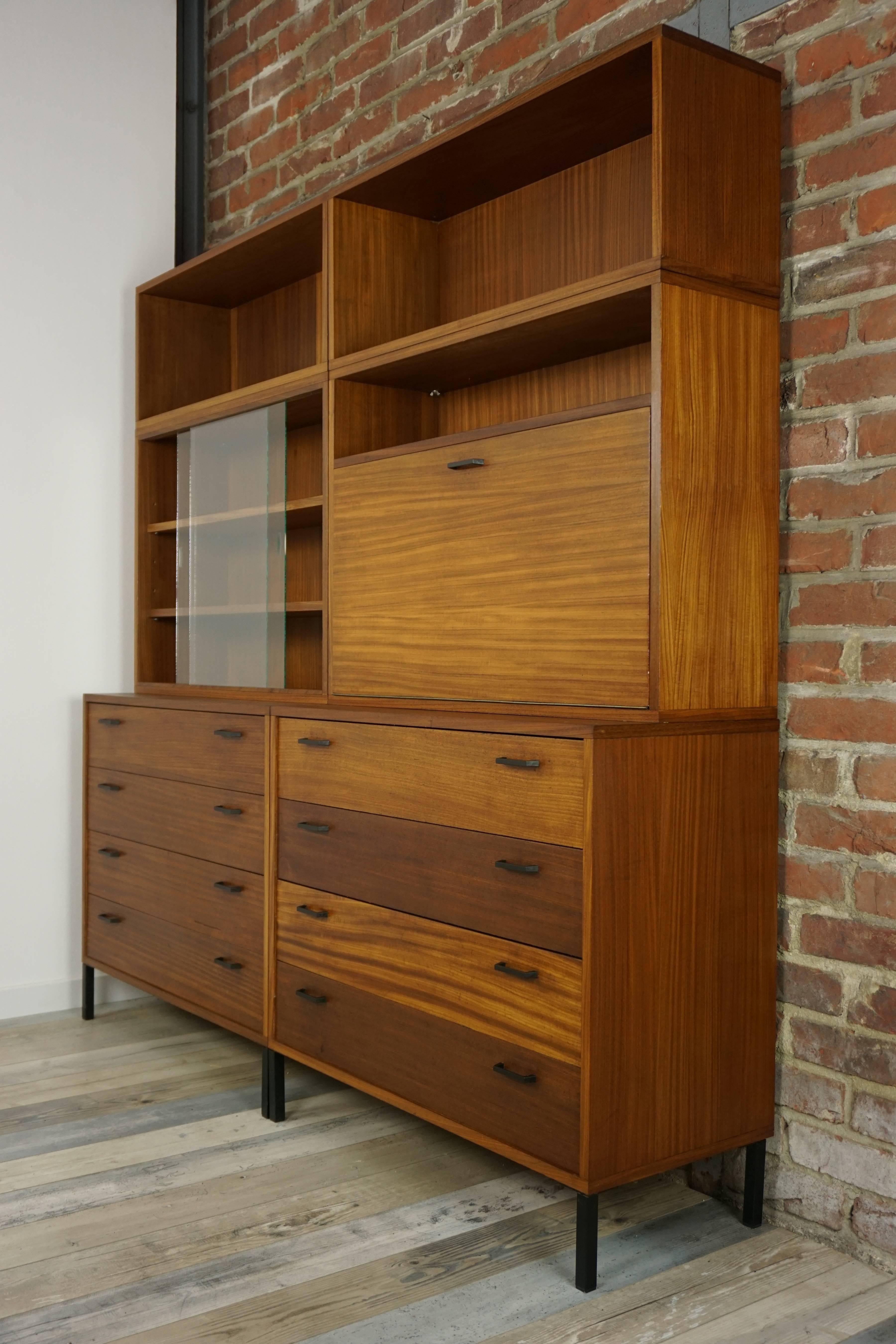 Beautiful modula wall unit cabinet with an integrated chest of drawers design from the 1950s composed in the lower parts of dressers four drawers combining, in its upper part, beautiful storage spaces with sliding glass doors, bar and bookcases.