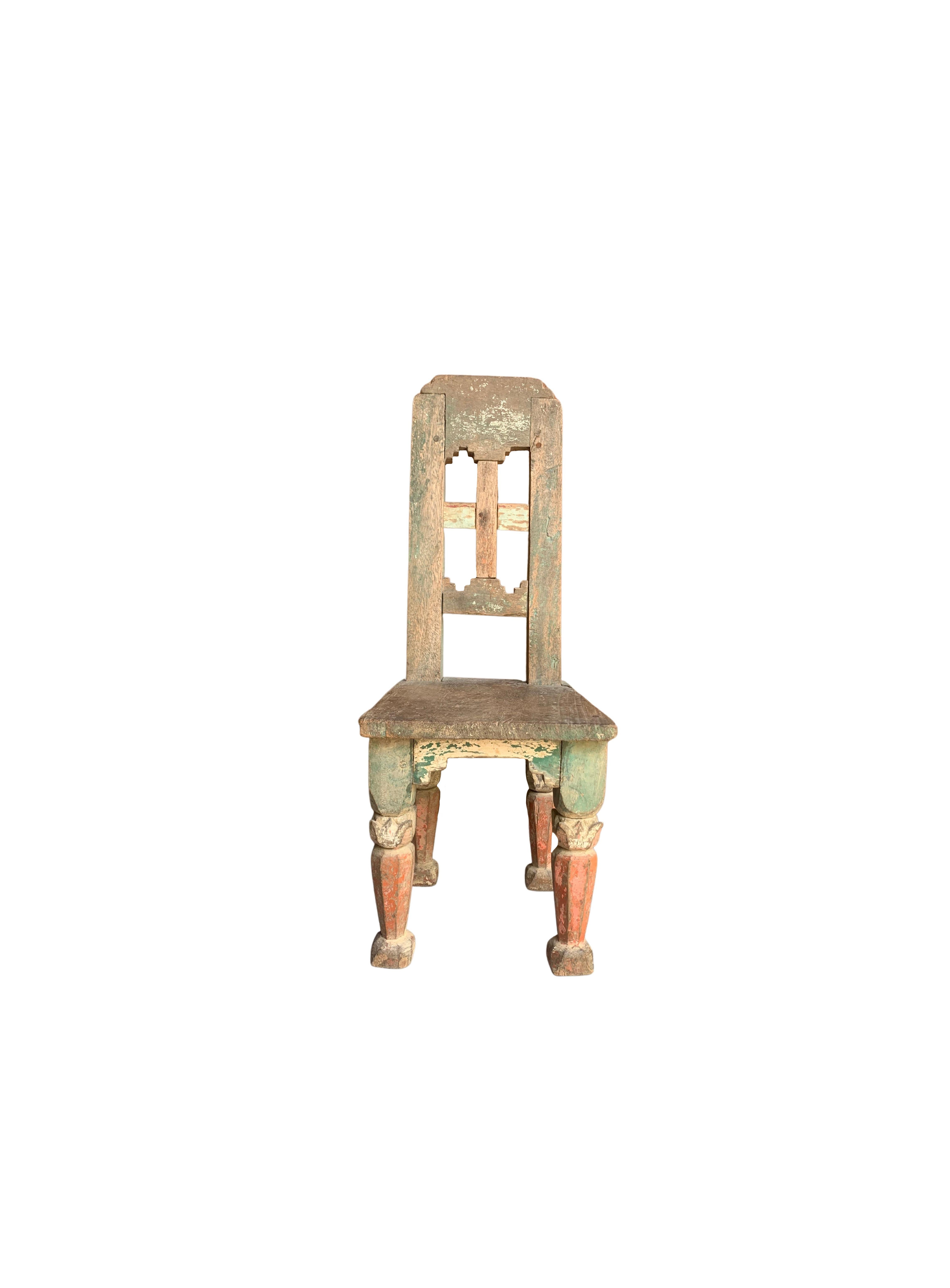 Mini Chairs such as these were once abundant amongst Indonesian tobacco plantations for workers to sit and cut cultivated tobacco. The present mini chair is an elegant example of such a chair, crafted from teak wood and featuring a red & green