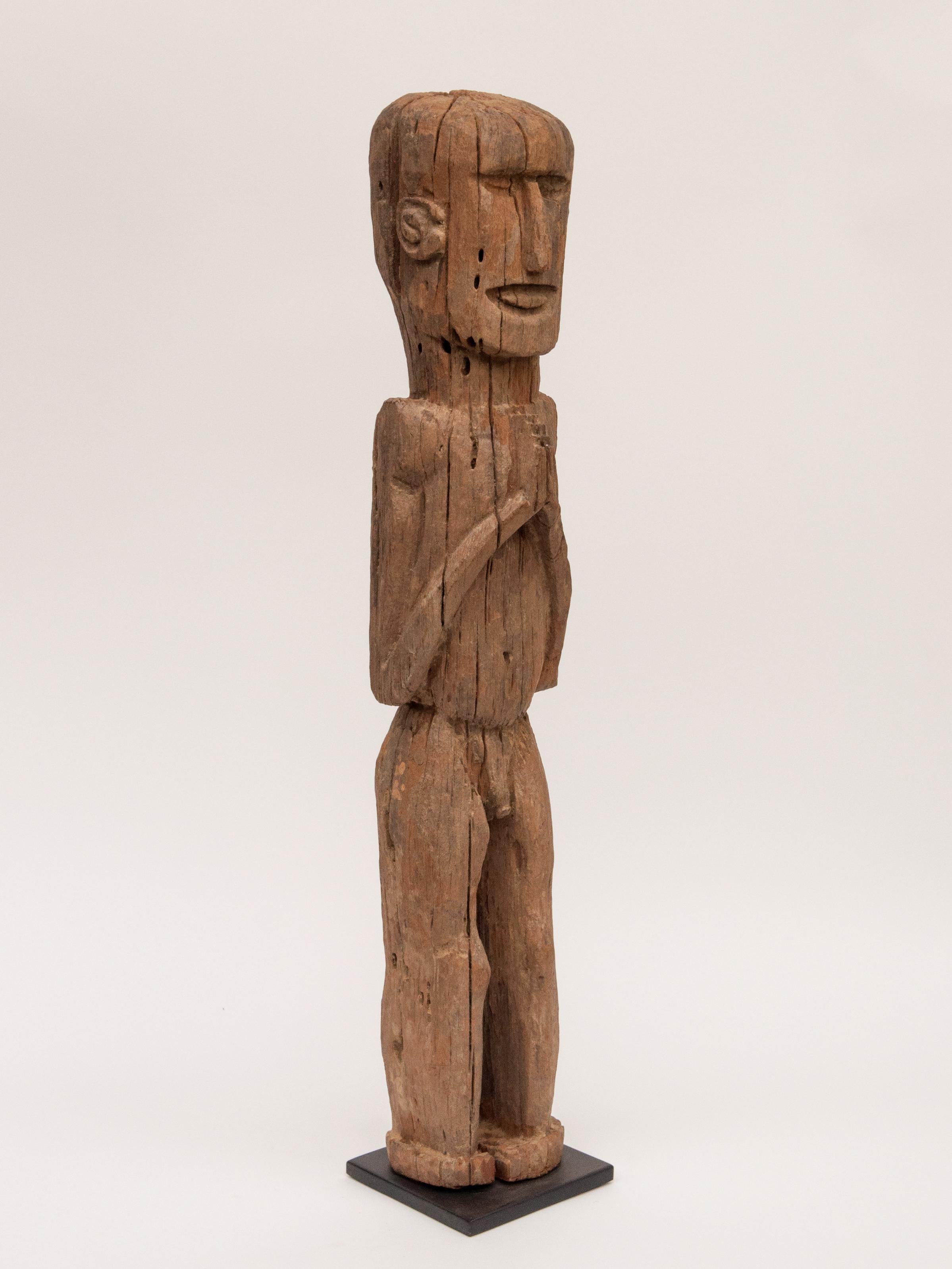 Wooden tribal male statue from West Nepal, early to mid-20th century. Mounted on a metal plate.
This wooden figure comes from West Nepal, most probably from the area of the Karnali river system. There is some mystery to these sculptures, which are