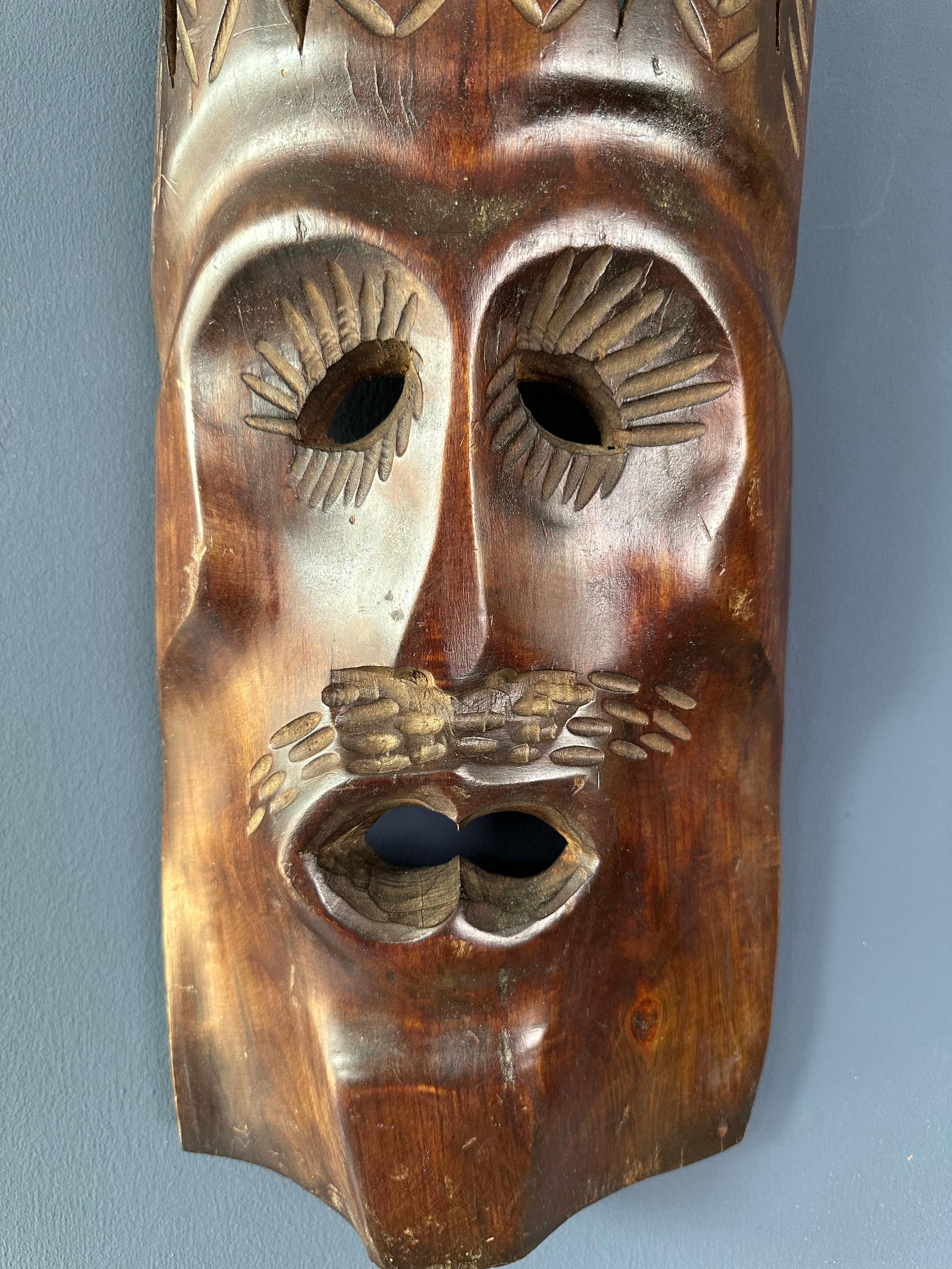 Aggiungi un tocco di cultura con questa sorprendente maschera tribale in legno. Il suo design intricato lo rende un pezzo decorativo accattivante per qualsiasi parete.