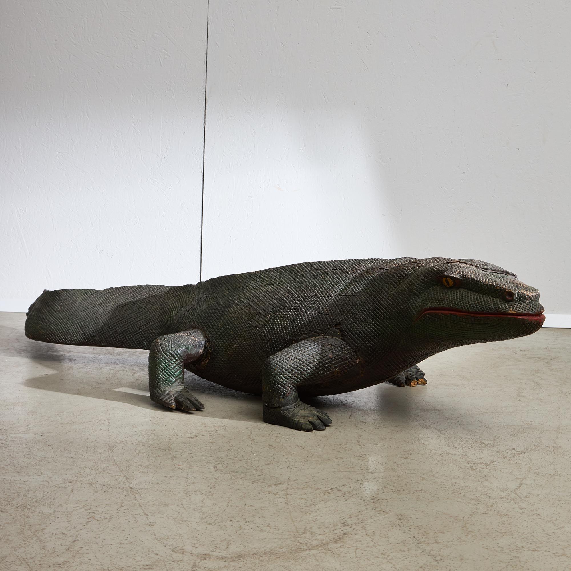 Una statua di varano in legno, anzi un vero e proprio capolavoro! Realizzato in legno massiccio, questo affascinante pezzo presenta dettagli intricati e minuziosamente intagliati che danno vita all'essenza del varano. Ogni curva e contorno è stato