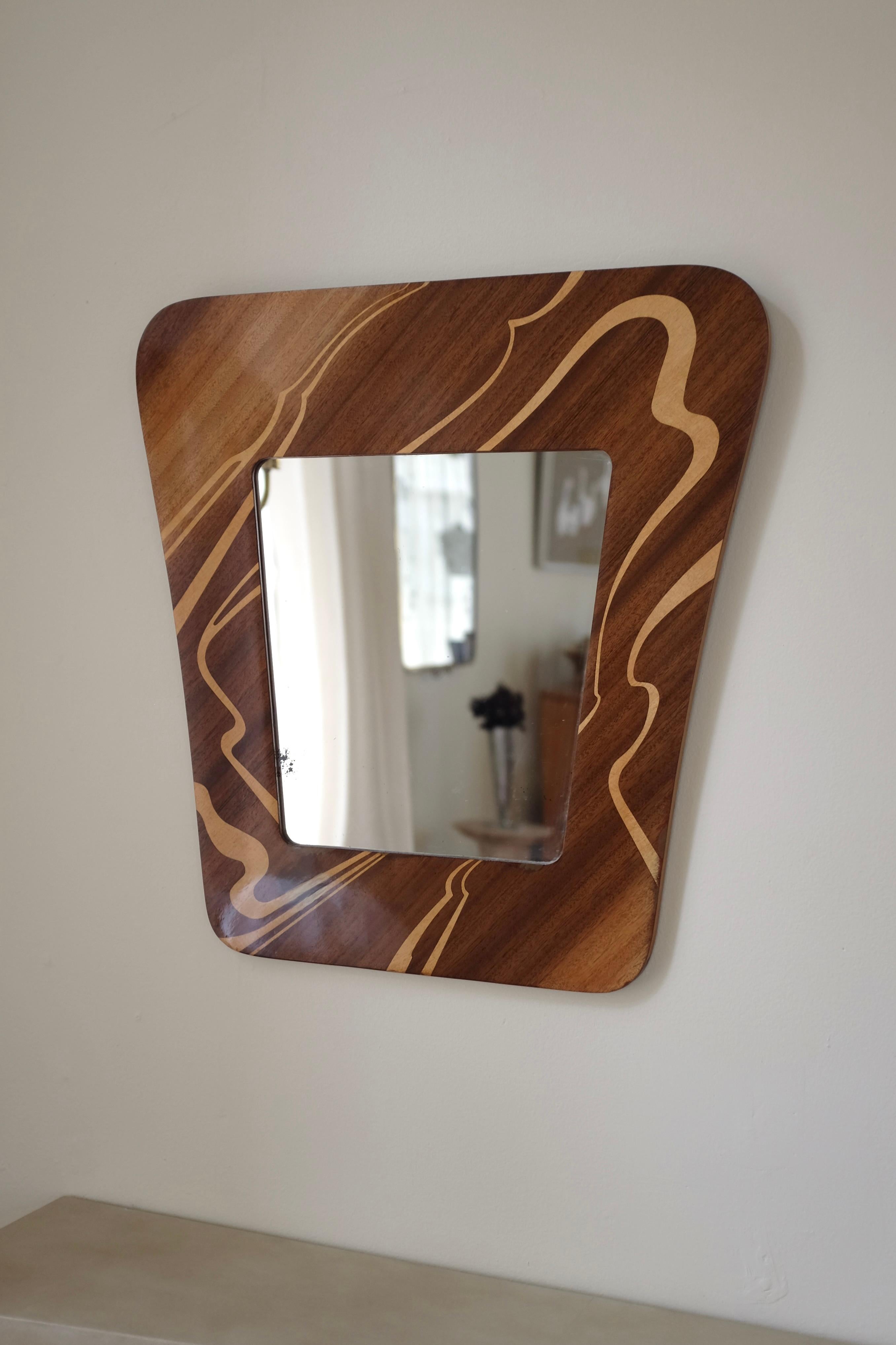 Specchio da parete in legno impiallacciato di Glas & Trä, Hovmantorp, Svezia, circa 1950. Bellissimo modello dalla forma organica con il legno più chiaro che si incurva intorno al vetro. Anche la forma dello specchio è di ispirazione organica,