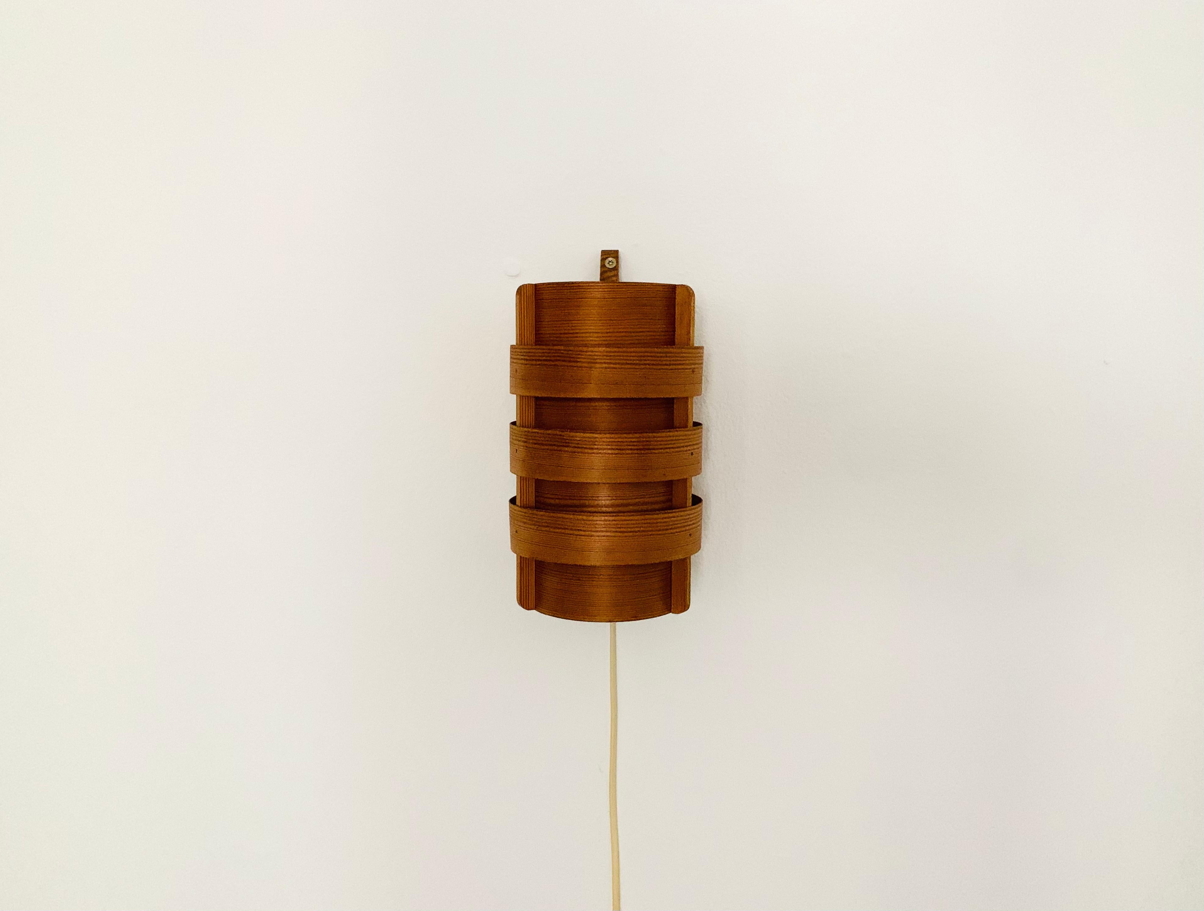 Extraordinarily beautiful wooden wall lamp from the 1960s.
Loving and high-quality processing.
The design and the material create a very warm and pleasant light.
The play of light created by the slats makes the lamp even more impressive.
