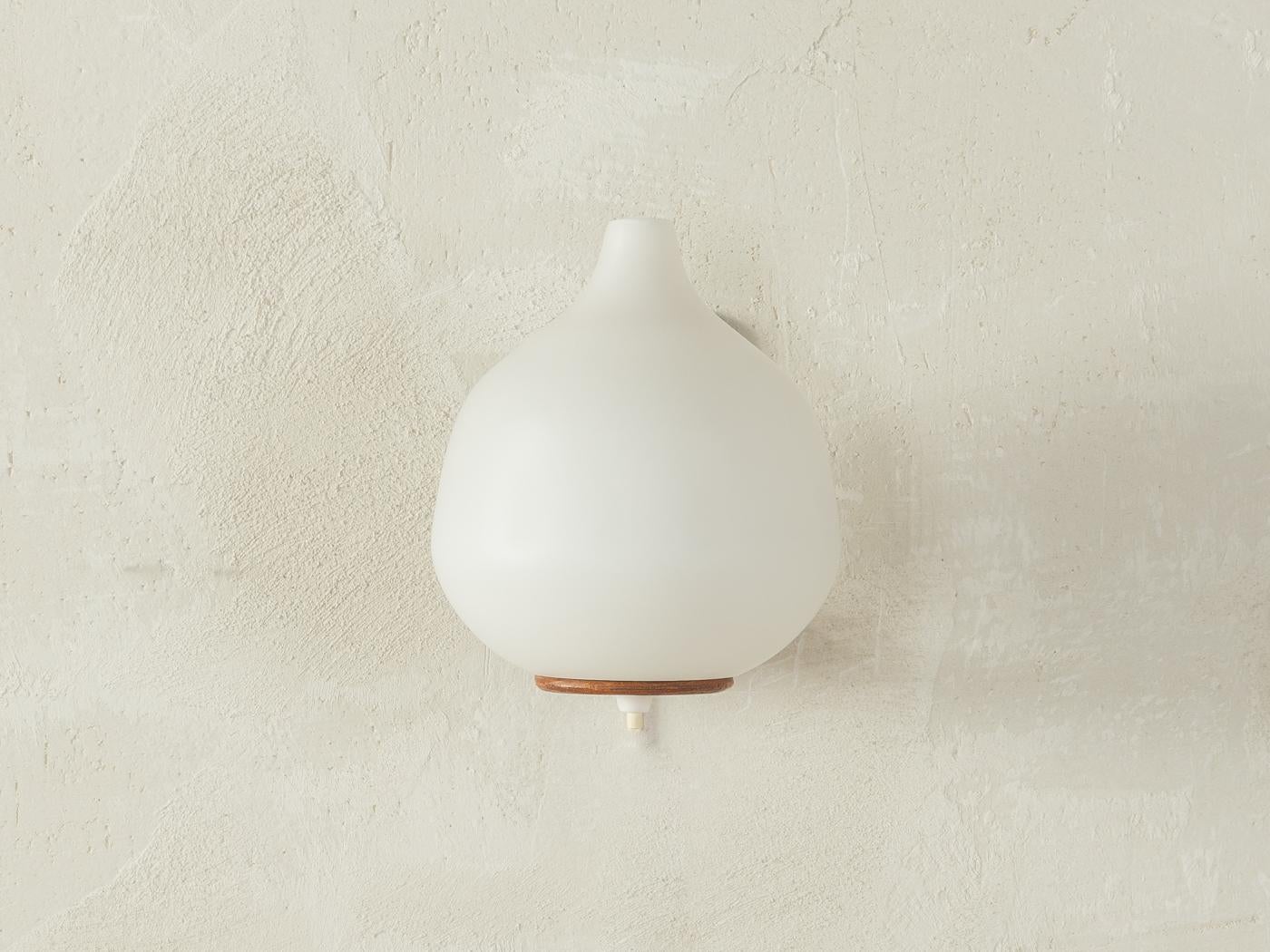 Rara lampada da parete degli anni '60 dal design scandinavo di Uno & Östen Kristiansson per Luxus. La lampada ha un paralume in vetro smerigliato e un supporto da parete in teak curvato. 

Caratteristiche di qualità:
ottima lavorazione 
materiali di