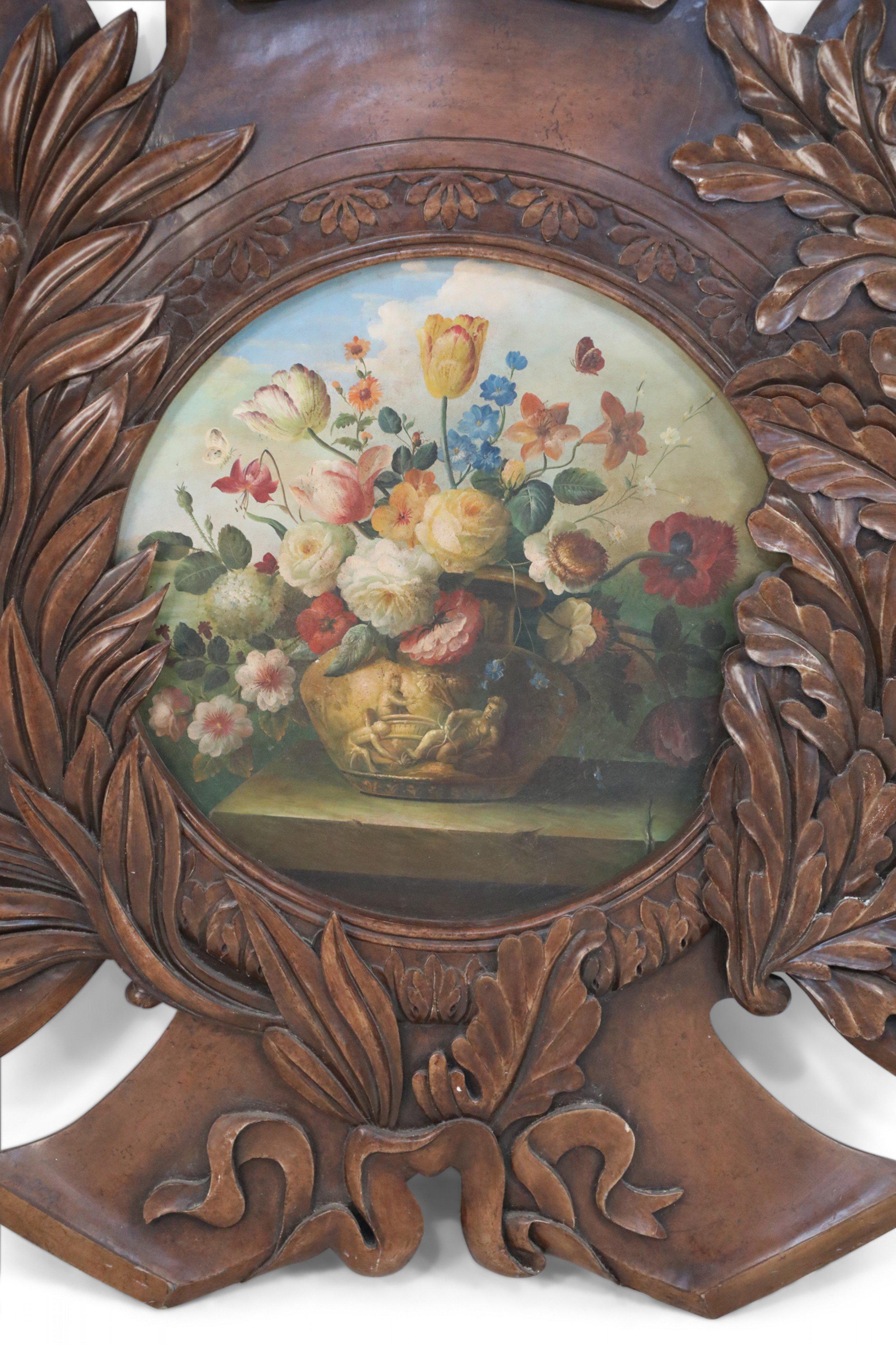 Vintage French Louis XV-style (20th Century) stained oak wall plaque carved with scrolls and laurels, framing a central still life oil painting of a floral arrangement.
  