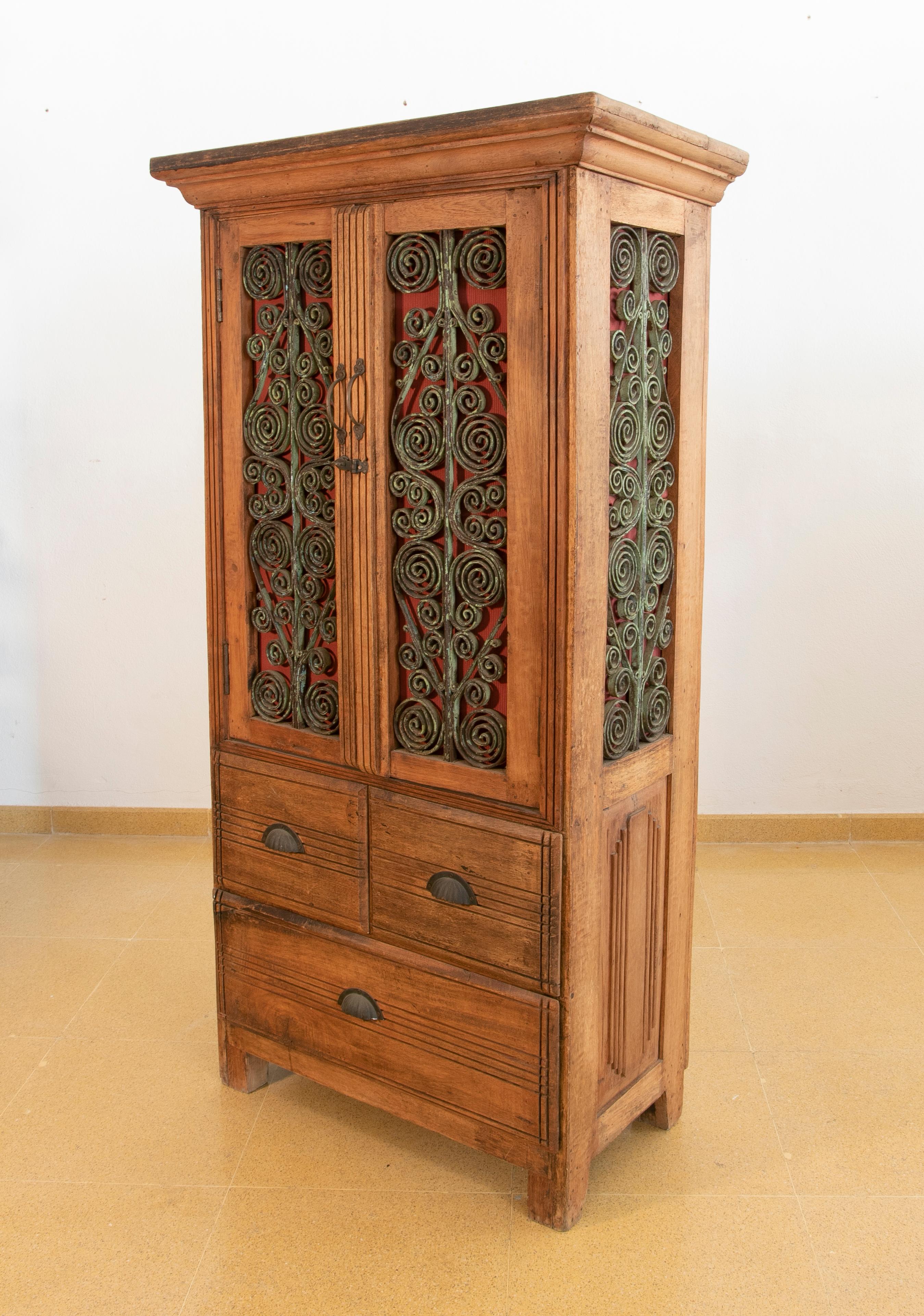 20ième siècle Armoire en bois avec portes et trois tiroirs décorés de fer en vente