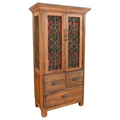 Armadio in legno con ante decorate in ferro e tre cassetti