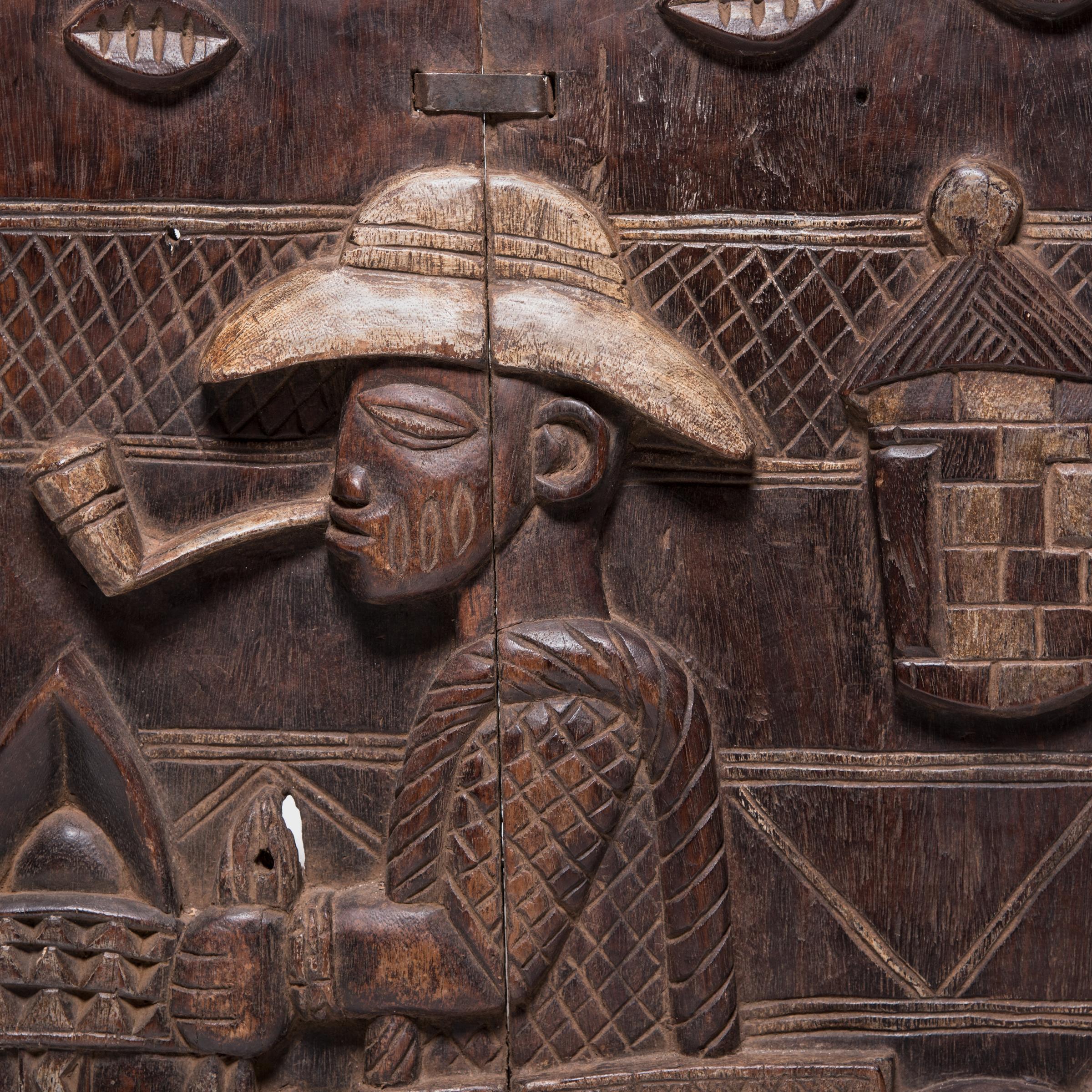 This decorative wooden panel was carved in high relief by a Yoruba artisan as an entry door to a prestigious home or palace.

Known as ilekun, such doors are typically created by master carvers and are commissioned by individuals of special