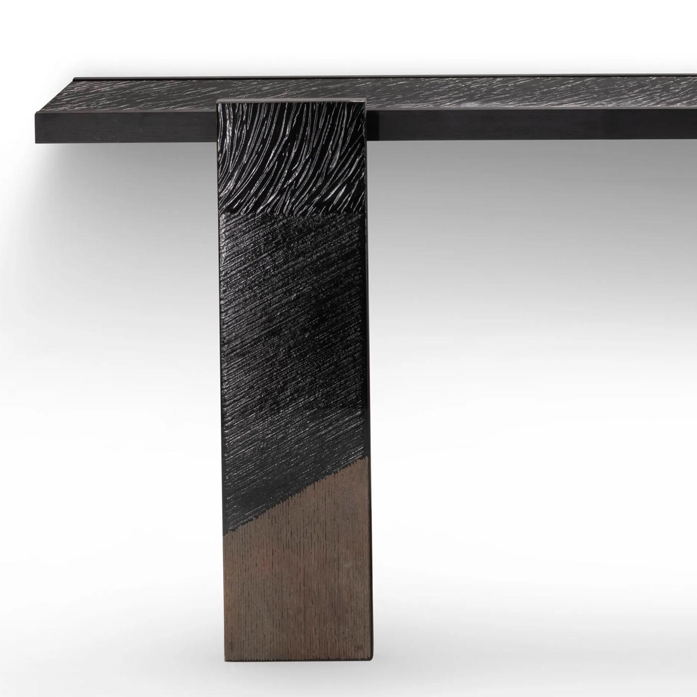Tavolo Consolle Woodenglass Wall con 3 parti tutte in legno in
impiallacciatura di frassino nero tinto, piano e gambe anteriori rivestiti in legno di frassino extra.
vetro trasparente inciso, con dettagli in vetro con finitura bronzata.