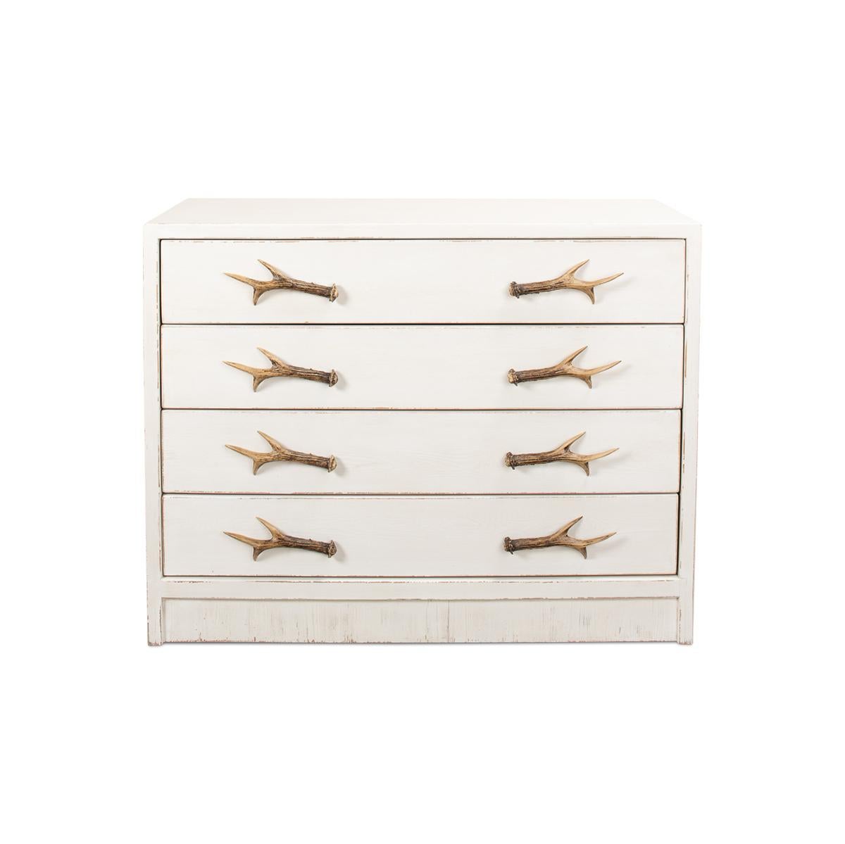 Pine chest of drawers has a whitewash finish and is accented with cast metal antler drawer pulls. 

Dimensions: 43