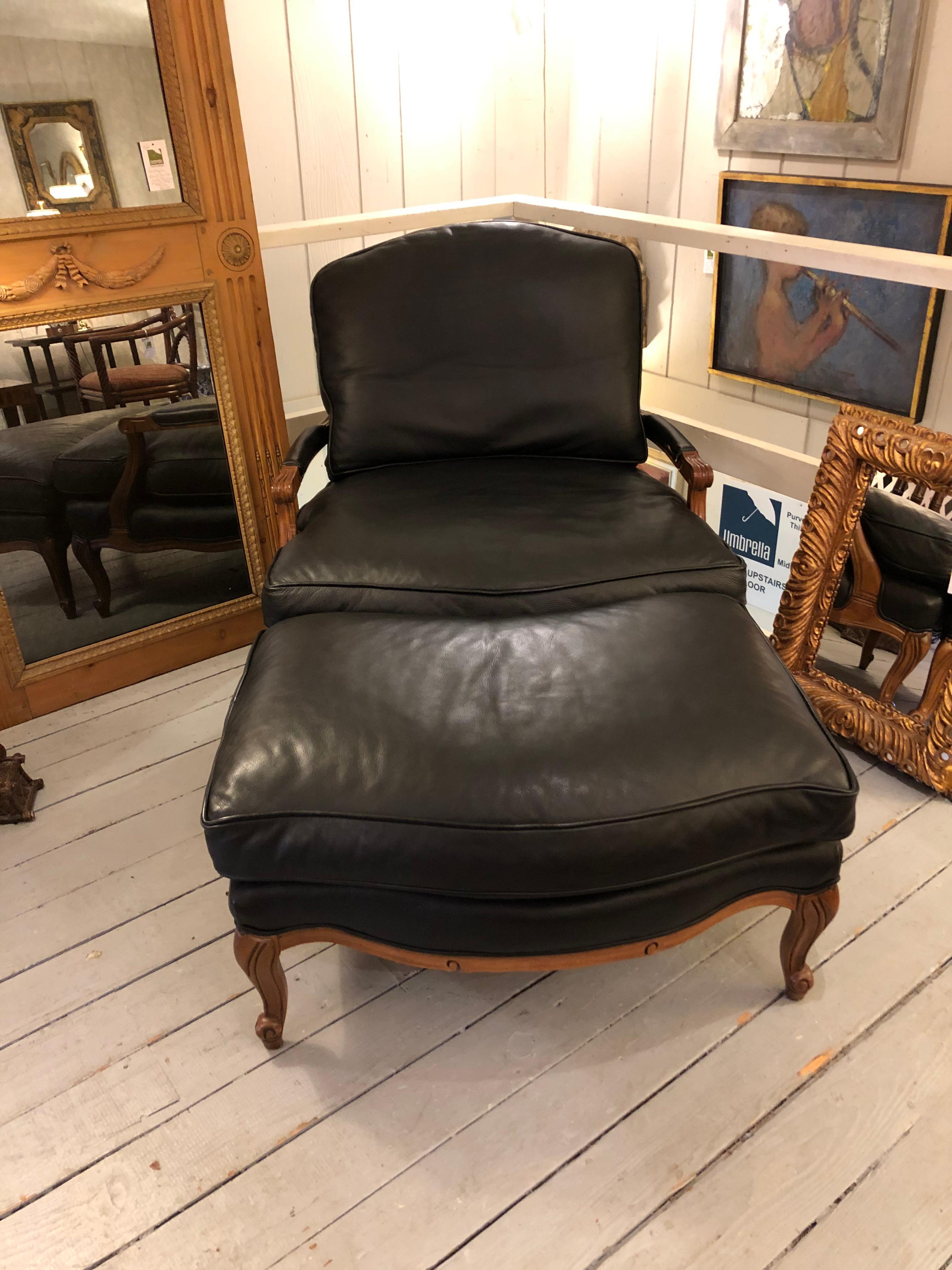 Luscious black leather club chair and ottoman that fit together like a glove and have warm contrasting carved walnut frame, arms, and legs.
Measures: Ottoman 23 D, 35 W, 18 H
Arm height on chair 21.5.