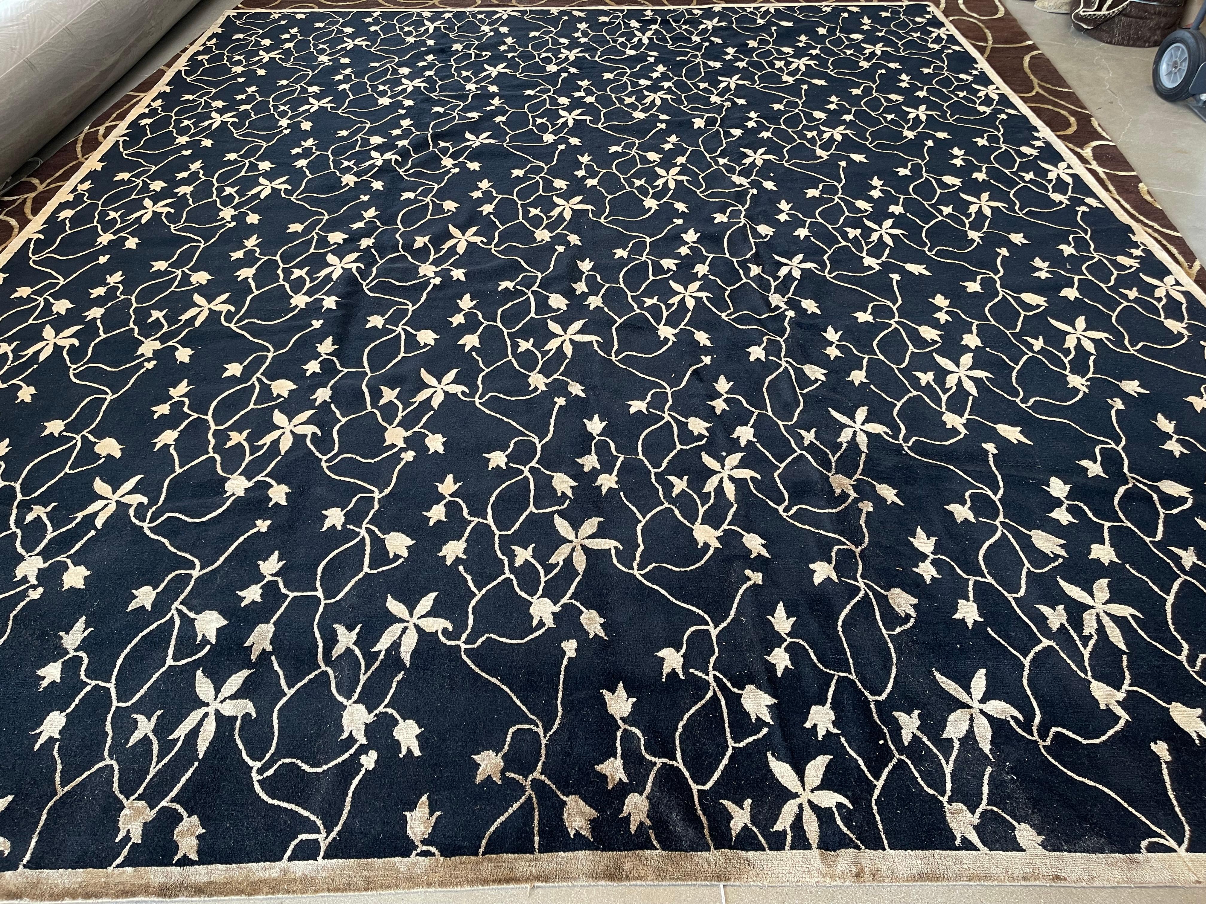 Add a dash of whimsy and warmth to a larger space with this black field wool with silk floral vines area rug. The wool silk blend brings durability, a sensuous texture and comfort underfoot. Suitable for home or office. 

Hand knotted in Nepal.