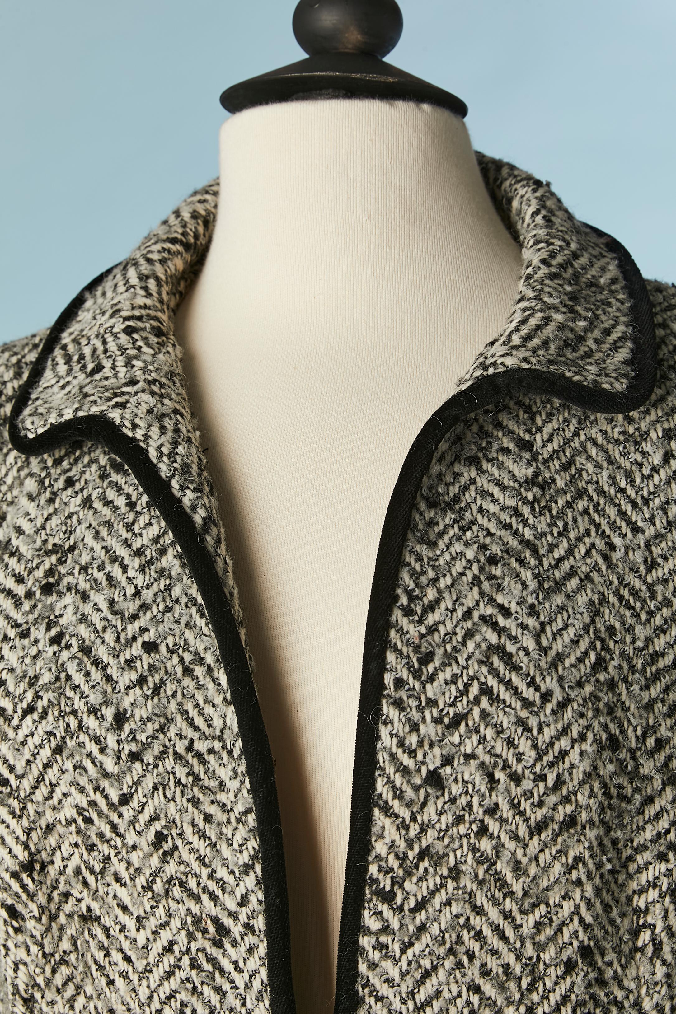 Combinaison jupe en laine à chevrons avec bord et nœud en velours noir. 
Composition du tissu principal : 48% laine, 30% acrylique, 15% nylon, 4% polyester, 3% rayonne. Doublure : acétate et rayonne. 
Epaulettes. Fermeture auto-agrippante sur le