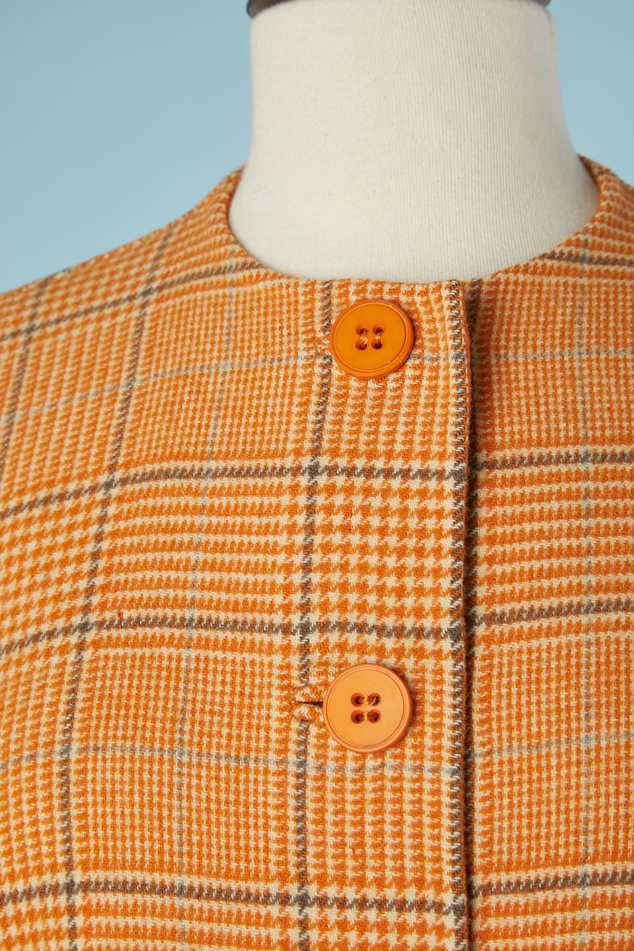 Manteau en laine double face ( carreaux et orange uni). Découpe à la taille. 
I.L.A. 