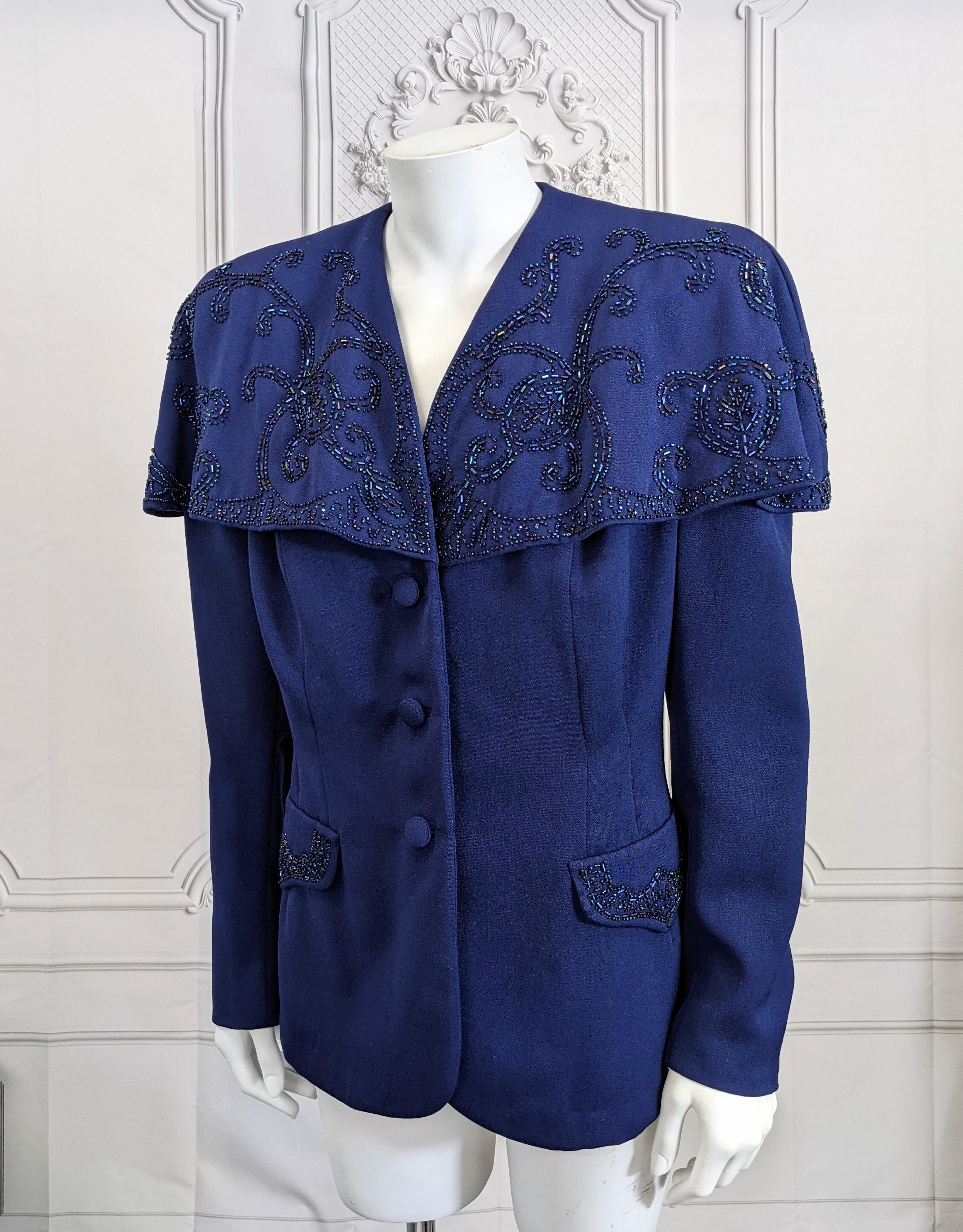 Attractive Wool Gabardine 1940's Jacket with Beaded Capelet in deep navy with aurora purple bugle bead swirl beading on attached capelet. 3 self covered buttons with fitted waist and strong shoulder pads. Bead work as well on faux pocket flaps.