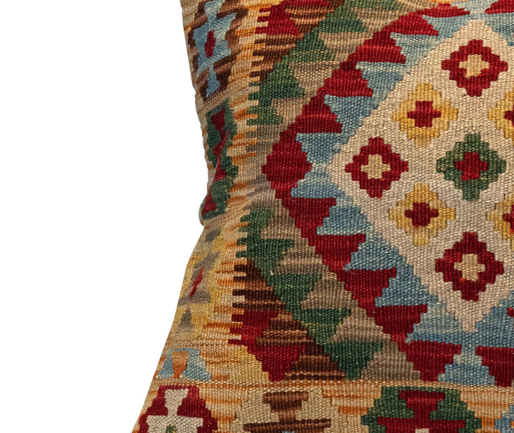 This fantastic cushion has been woven by hand using traditional kilim weaving techniques with hand-spun wool. Featuring a symmetrical geometric pattern woven in beautiful rustic colours. Including olive green, red, yellow and blue. These elegant