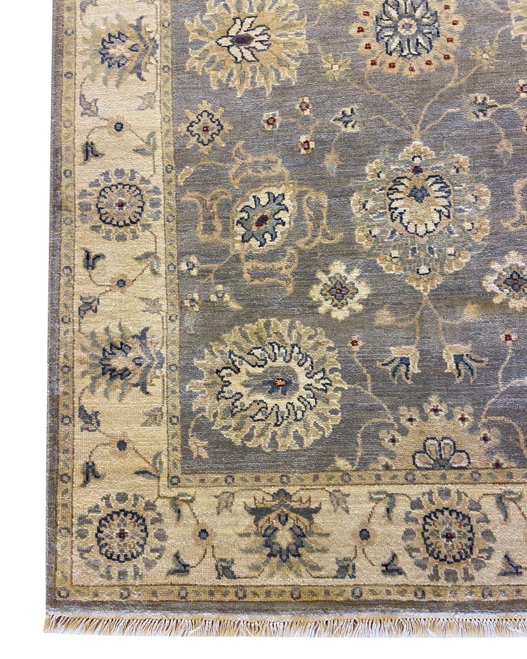 Questo tappeto persiano in lana grigio acciaio e crema annodato a mano con motivi floreali, che misura 4' x 6', fonde perfettamente la tradizionale arte persiana con una raffinata estetica contemporanea. Il campo grigio acciaio costituisce una base