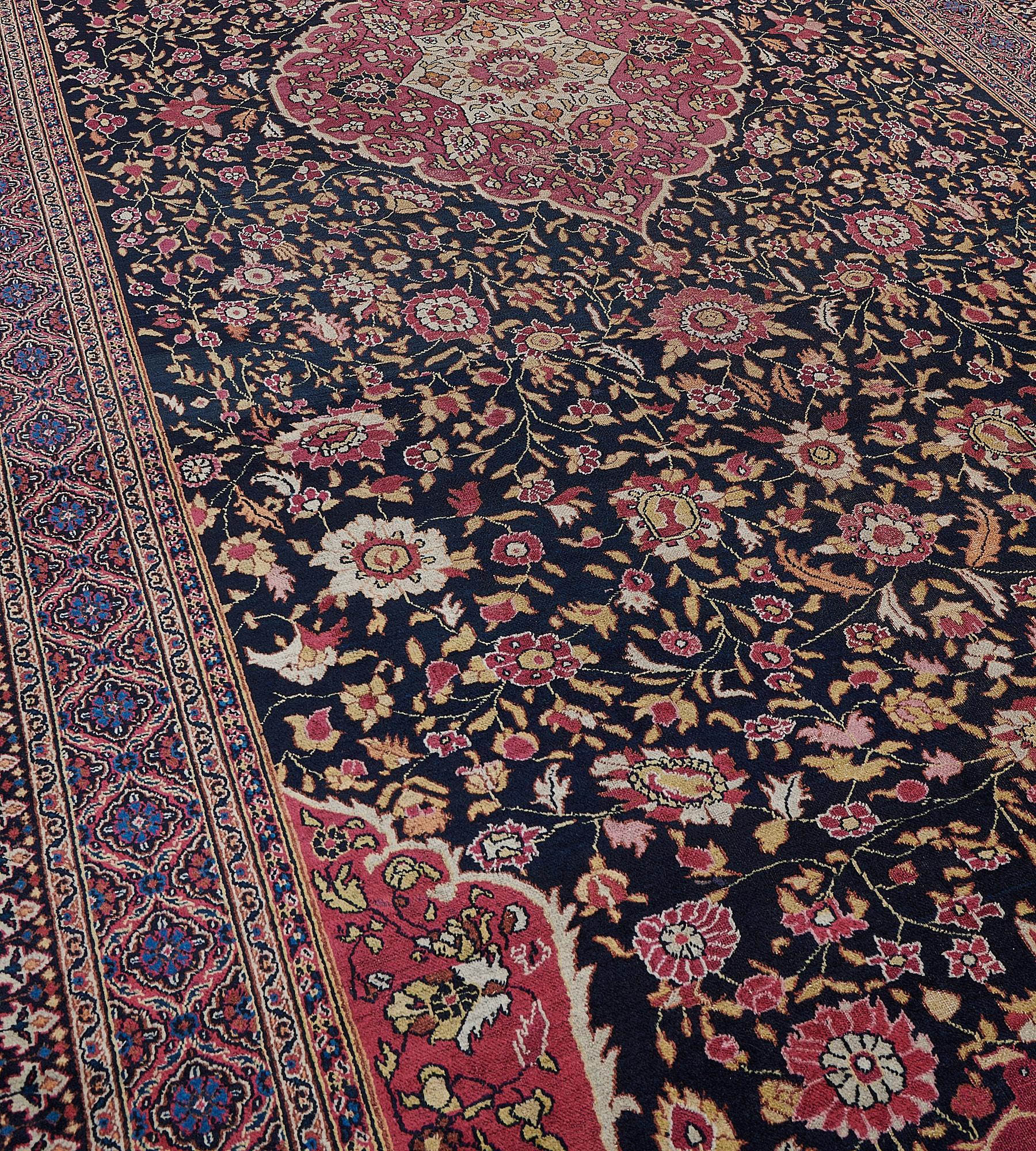 This handwoven antique, circa 1880, Khorassan rug has a charcoal-black field with a dense polychrome floral vine around a shaded raspberry-red cusped medallion with palmette pendants the ivory central stellar-flowerhead lozenge containing floral